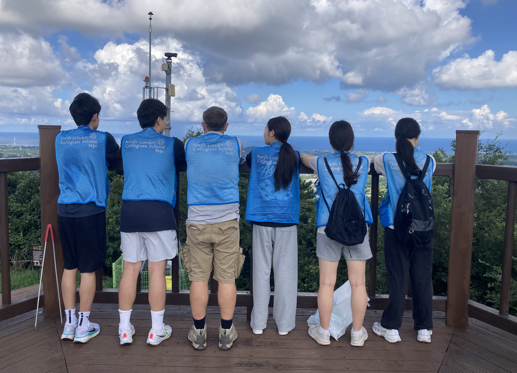 Ecomusician ambassadors at Jeoji Oreum observation deck overlooking the ocean