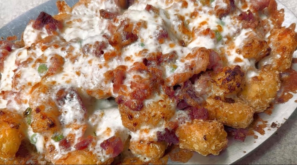 Crispy buffalo wings with glossy buffalo sauce and blue cheese dip on a dark slate board