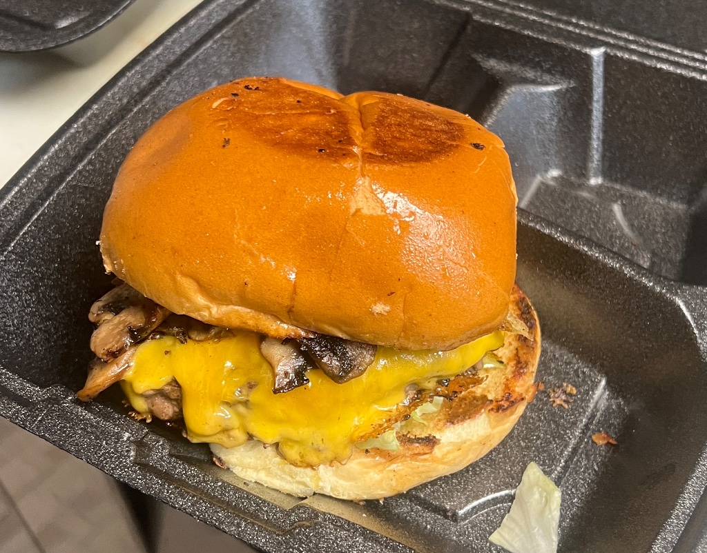 Gourmet steakhouse burger with melted cheddar, crispy bacon and caramelized onions on a brioche bun