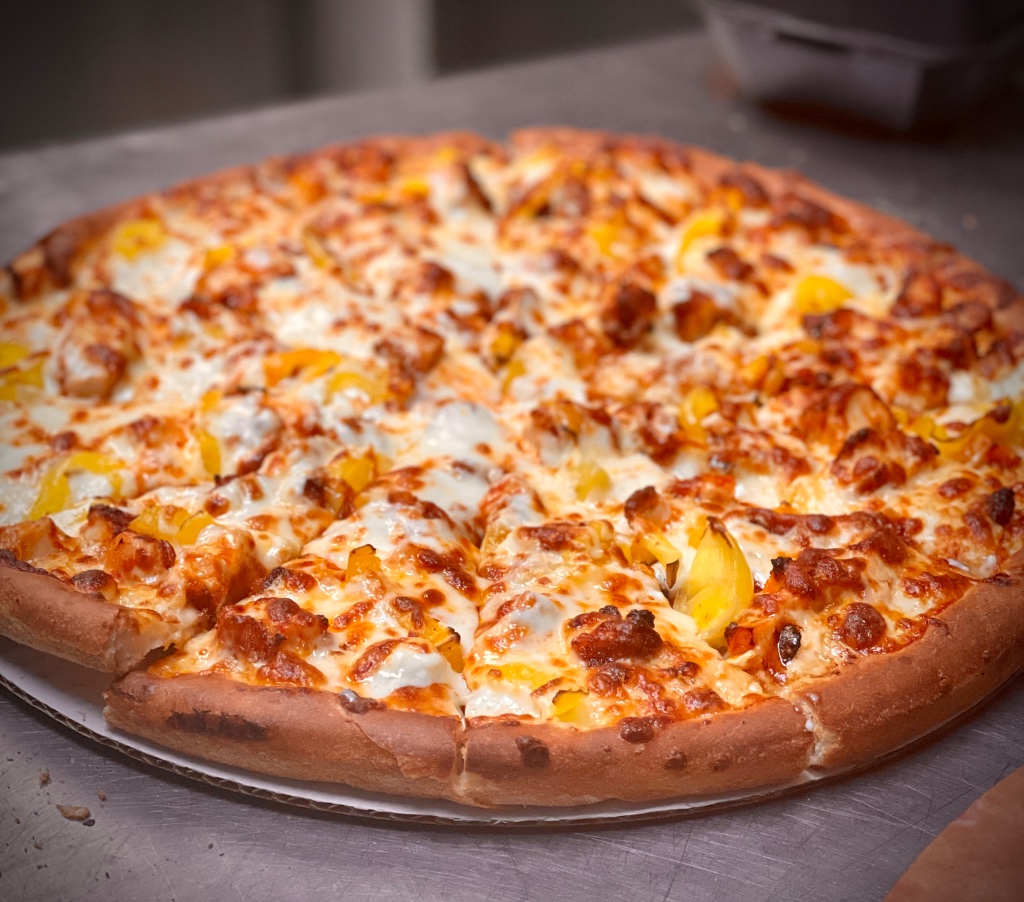 Greek-style pizza fresh from the oven with bubbling mozzarella and a golden, thick crust