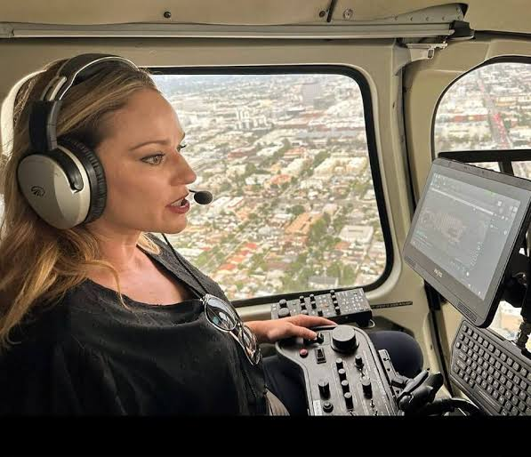 Amy Metz wearing a headset aboard a helicopter