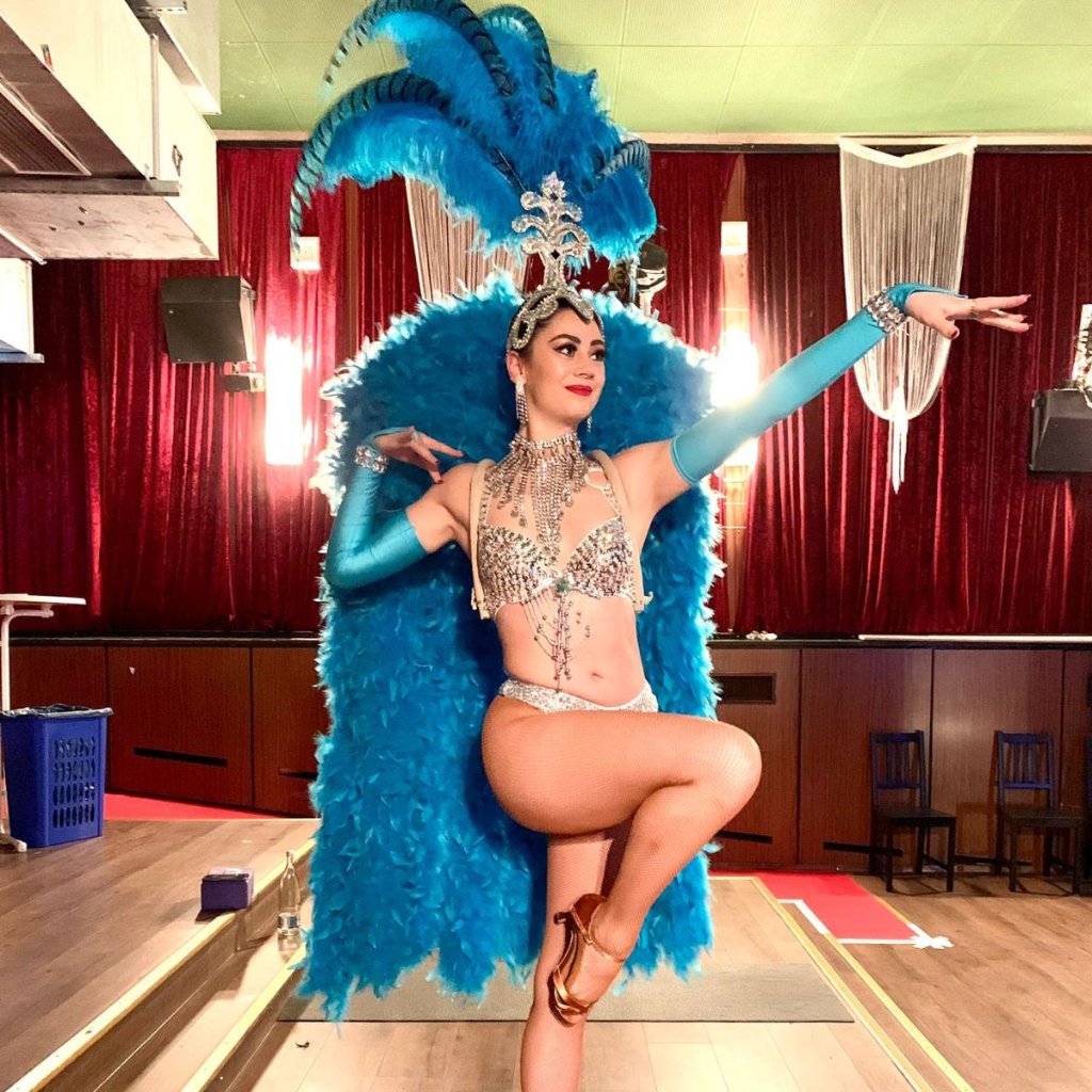 Blue feathered showgirl at London event