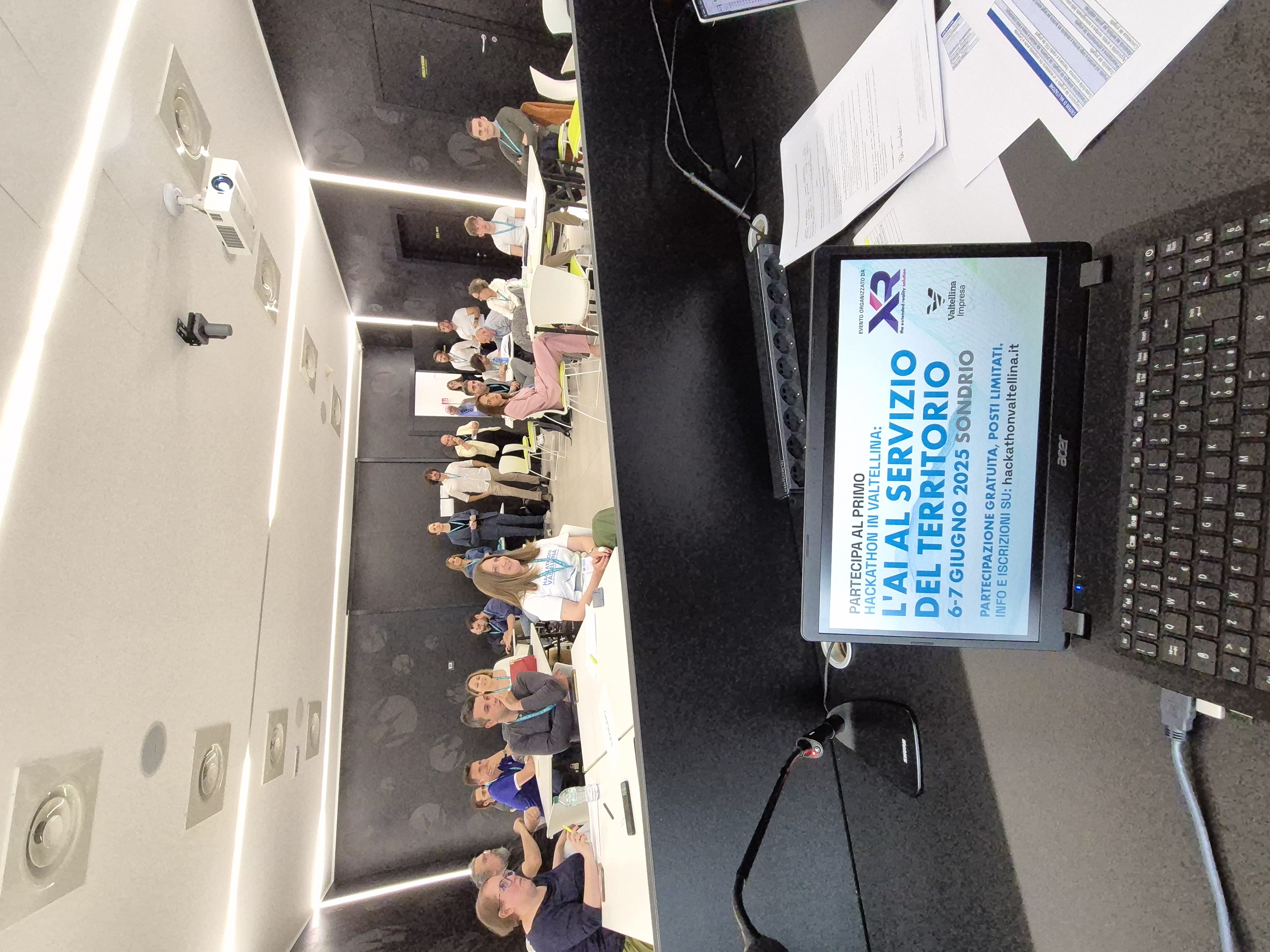 La sala del kick-off vista dal tavolo dei relatori, con la locandina sullo schermo