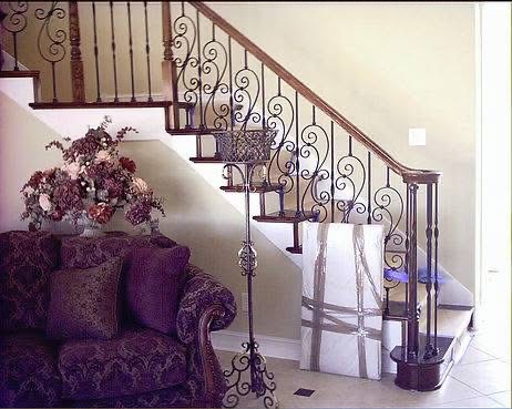 Grand foyer staircase with iron scroll balusters and dark wood treads in Goodland, Florida