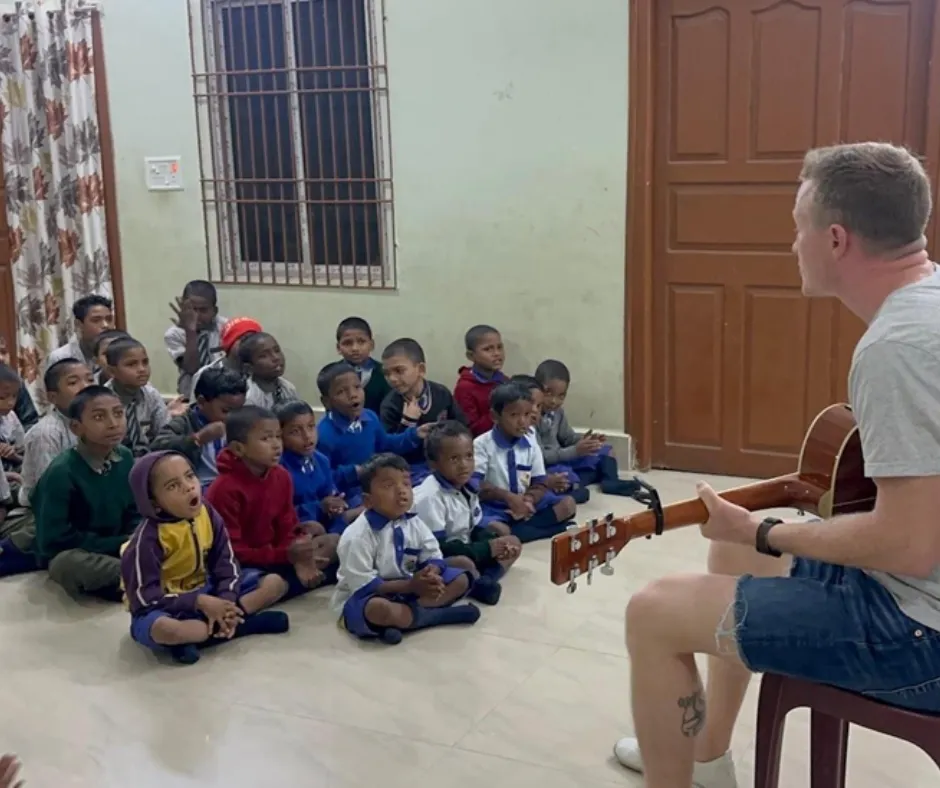 James playing guitar for children