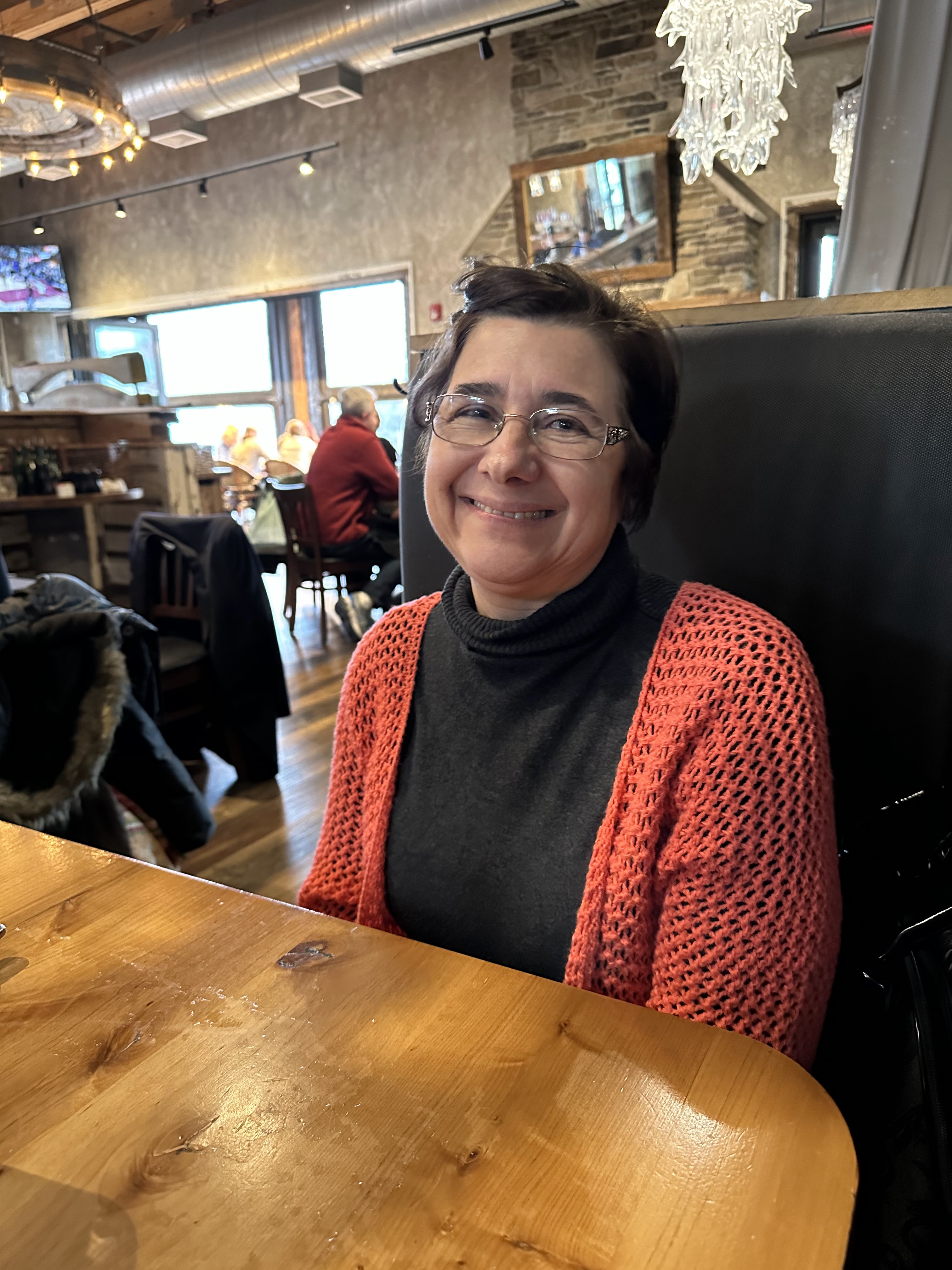 Marisa smiling at a table in a restaurant