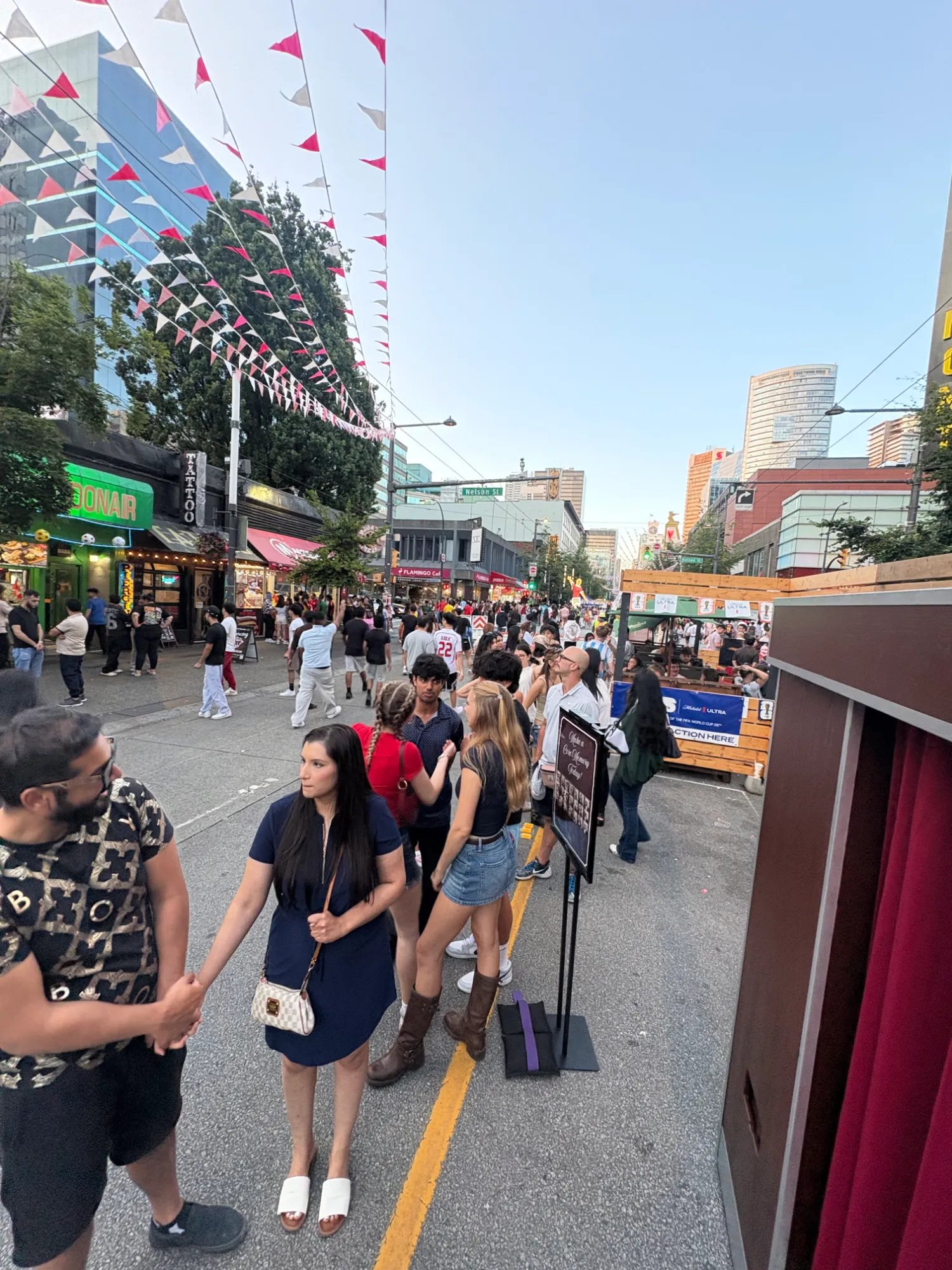 A wide view of the Granville Street crowd and pennant flags at the FIFA World Cup fan event in Vancouver