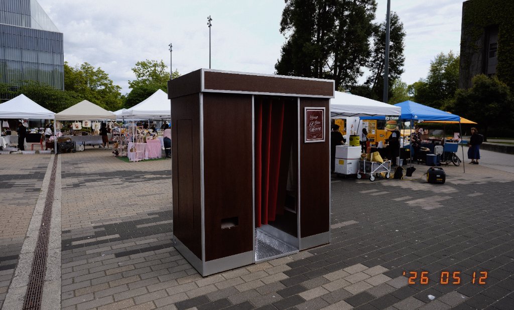 The Retro Booth's enclosed, vintage-styled photo booth cabinet set up outdoors at a Vancouver-area market event