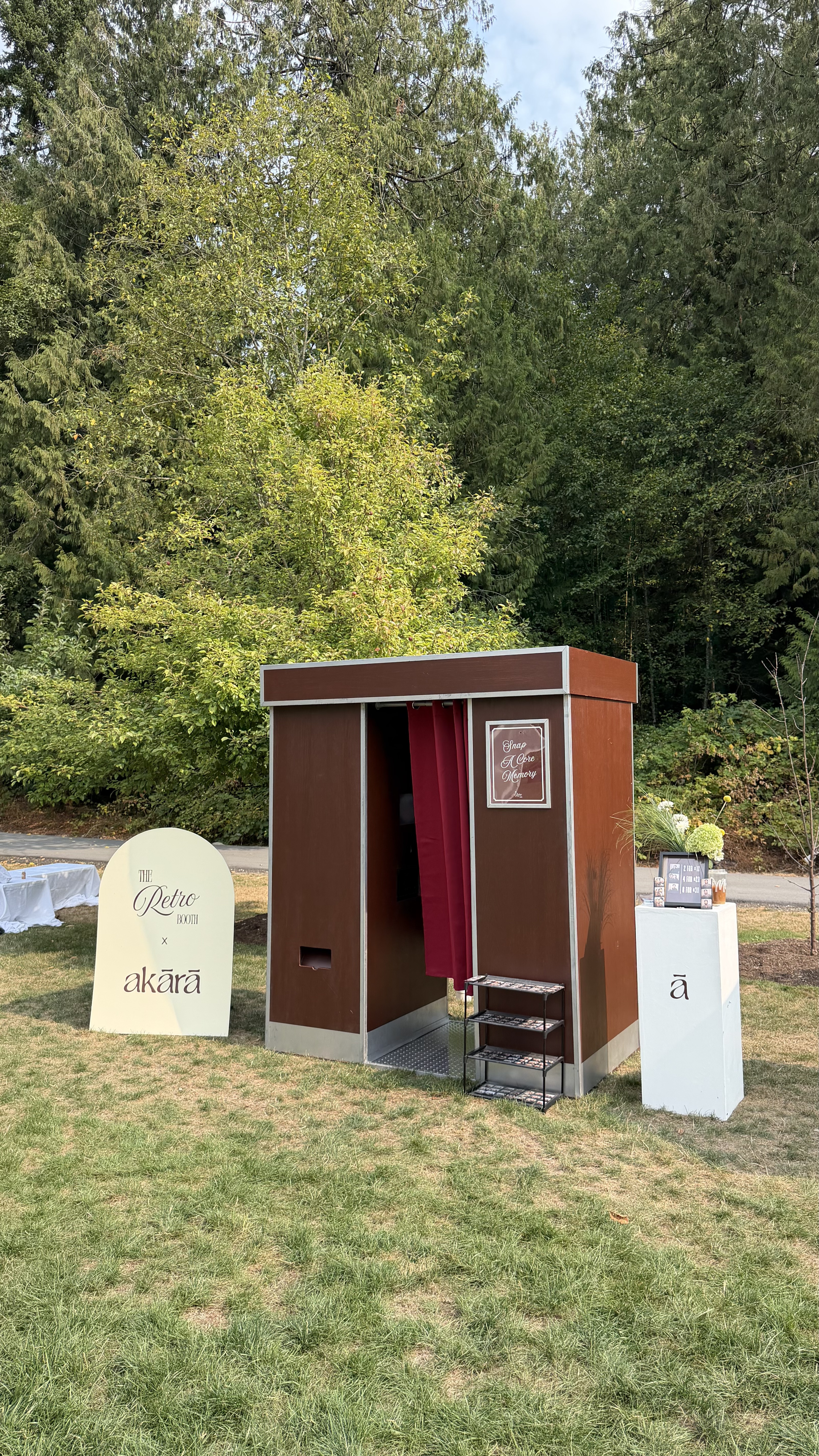 The Retro Booth's enclosed vintage photo booth set up outdoors at a real Vancouver-area corporate event, with a Retro Booth x Akara branded sign