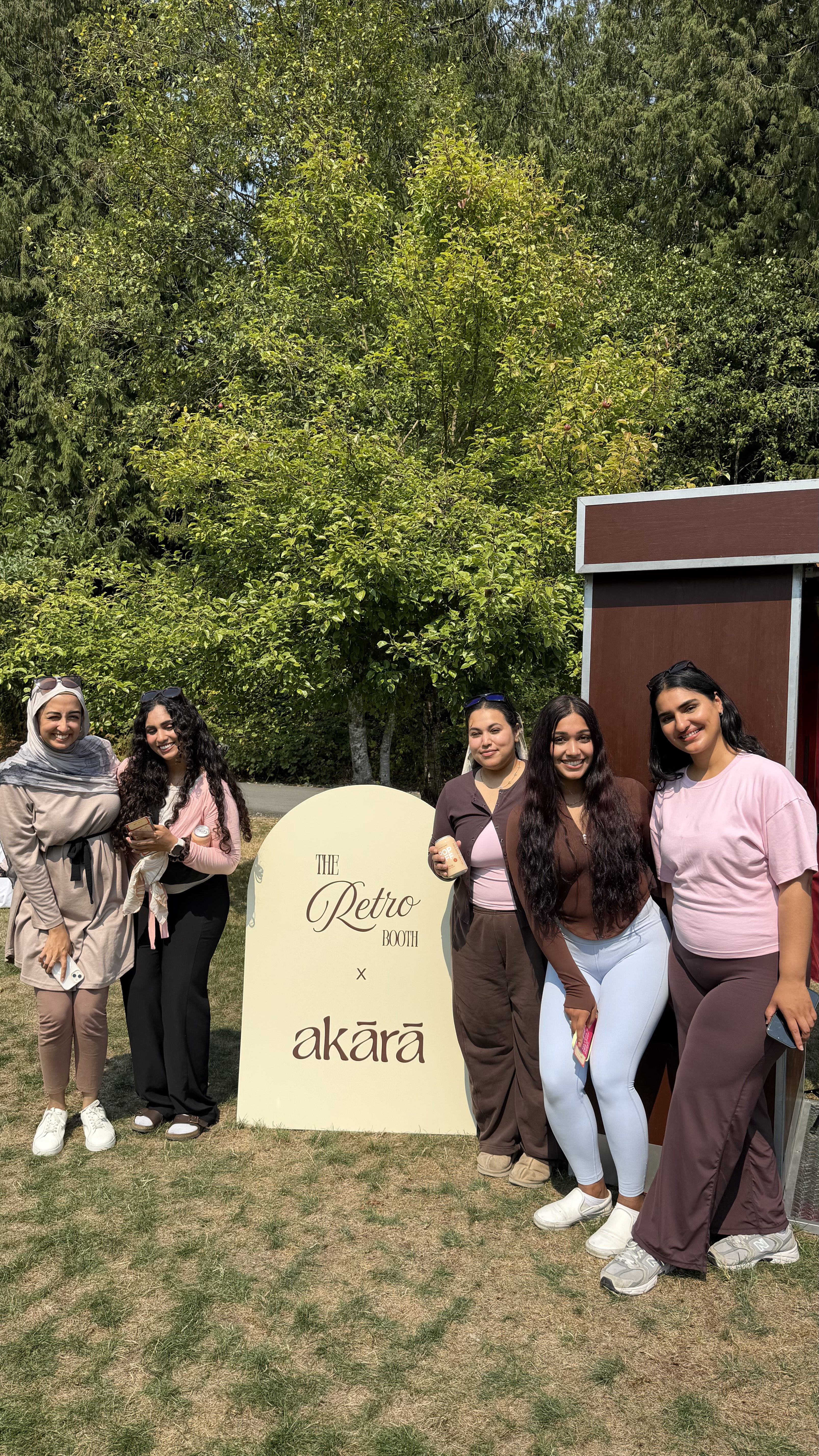 A group of guests posing beside a Retro Booth branded sign at a real Vancouver-area corporate event