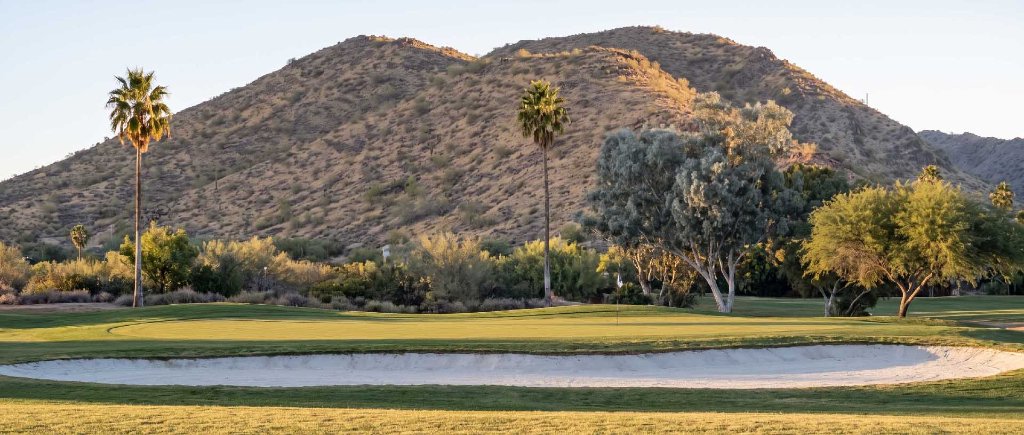 Golfers walking the course at sunset