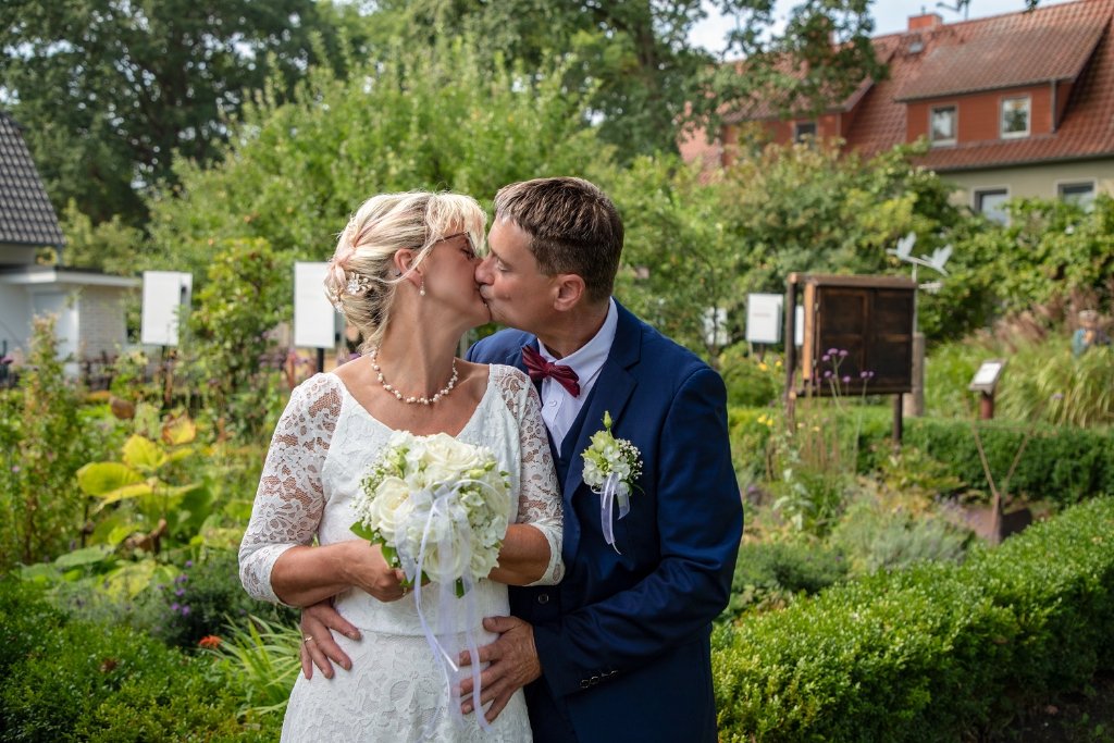 Brautpaar küsst sich im Garten in Zingst