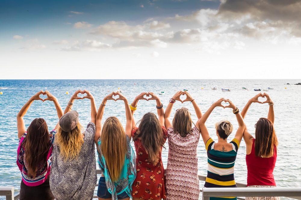 Hochzeitsgäste mit Herzhand-Gesten am Ostseestrand von Glowe – Strandhochzeit Rügen