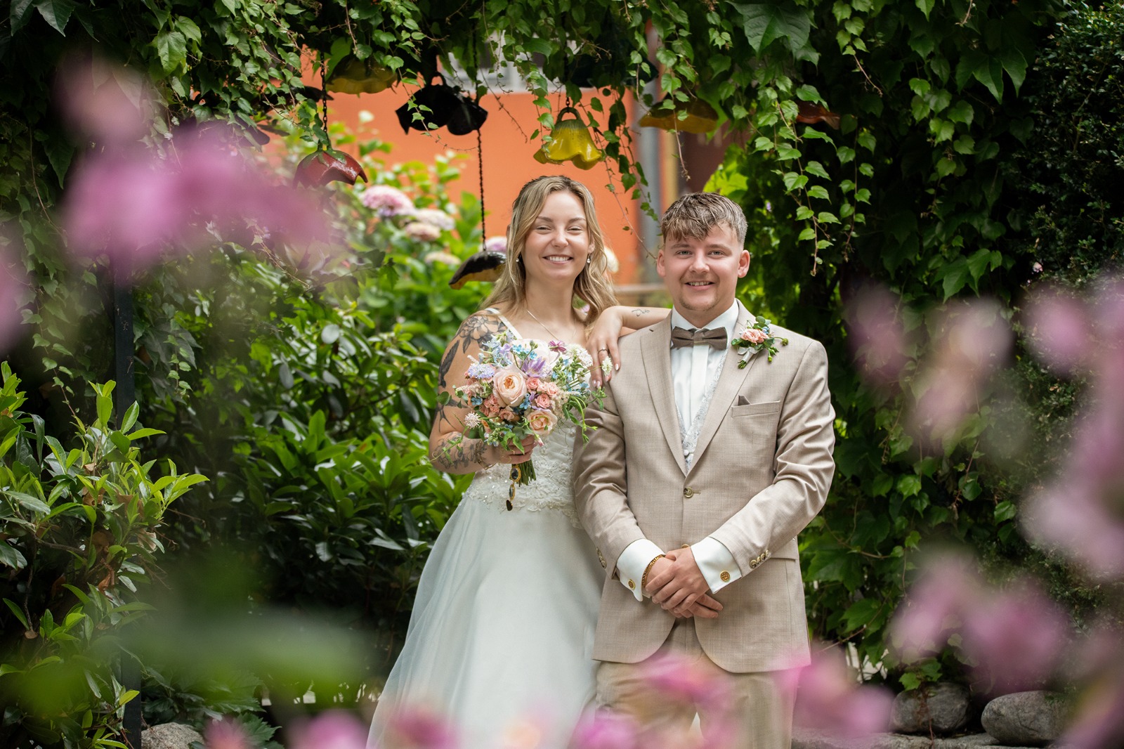 Hochzeitsfotograf Stralsund – Brautpaar unter grünem Laubengang beim Johanneskloster