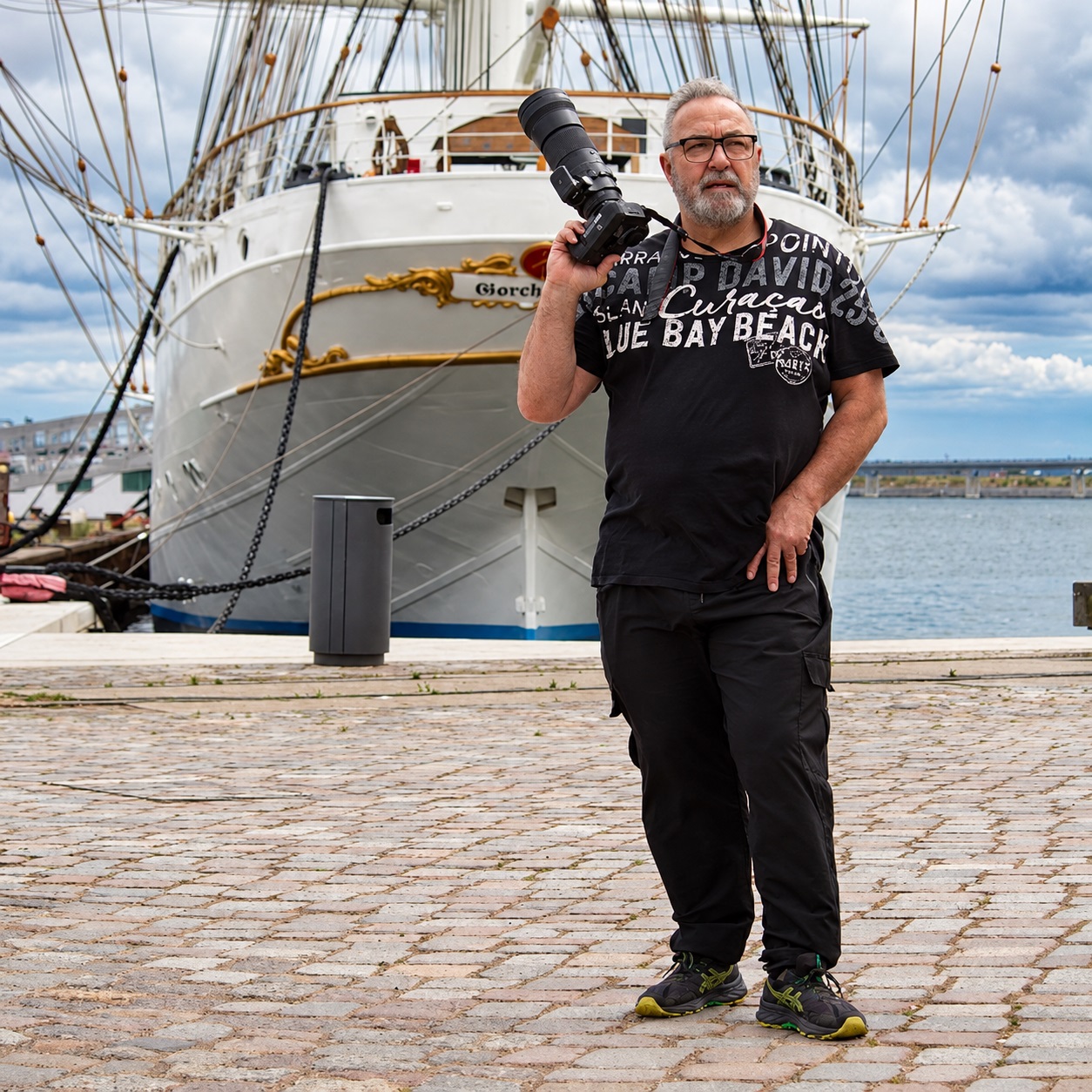 Hochzeitsfotograf Karl-Heinz Fischer aus Stralsund mit Kamera vor historischem Segelschiff im Hafen