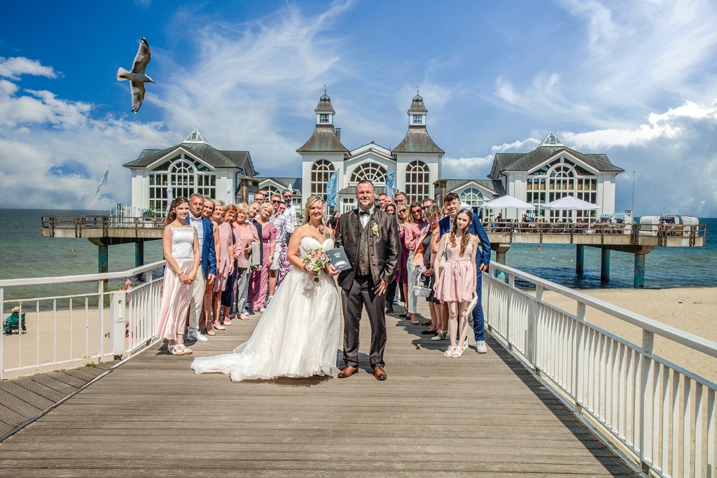 Brautpaar mit Hochzeitsgesellschaft an der Seebrücke Sellin – Hochzeitslocations Rügen