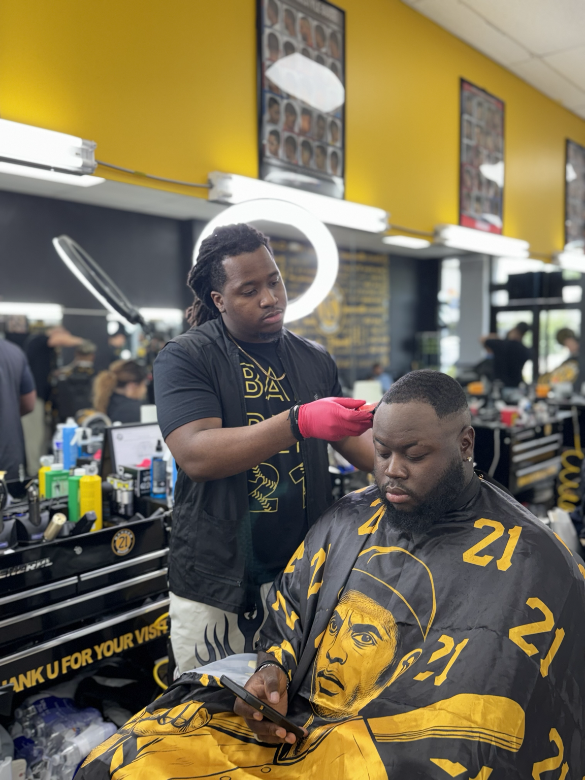 Barber with clippers working on client