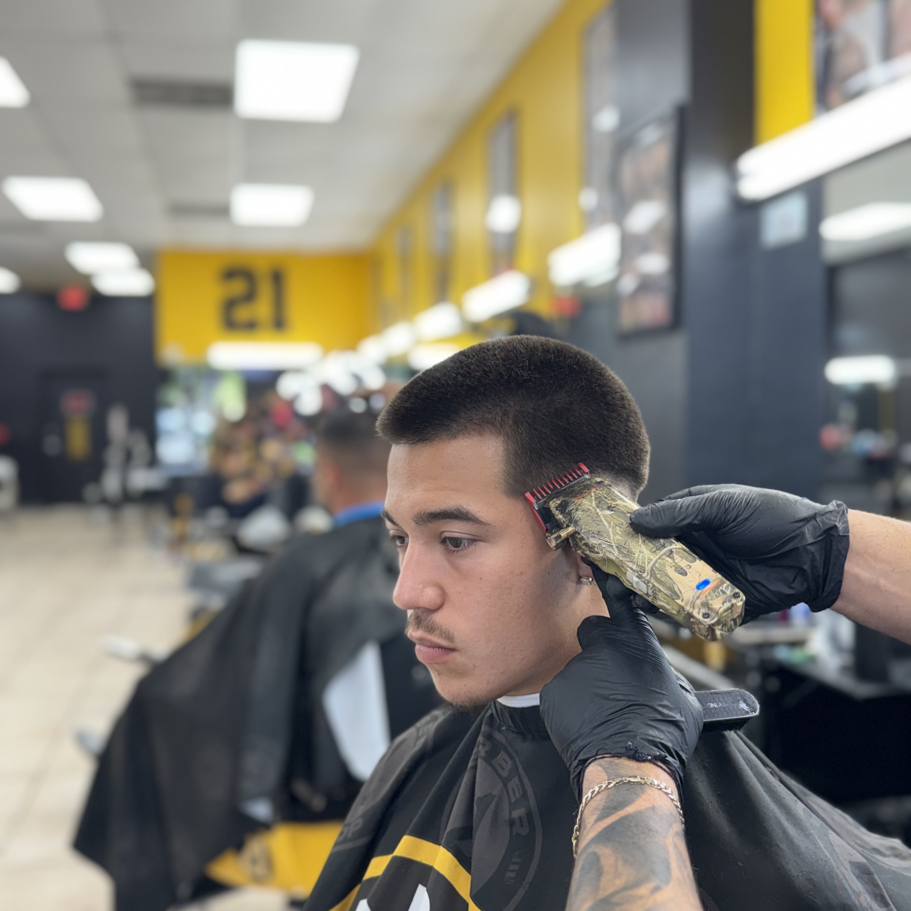 Barber trimming fade with clippers