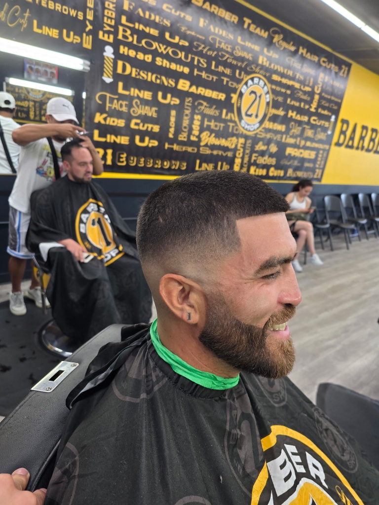 Haircut in progress at branded wall
