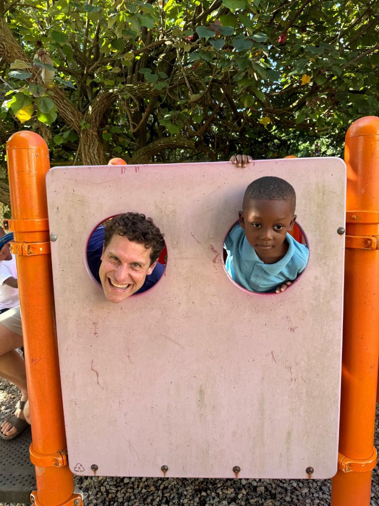 Playing peekaboo with a child at an upcycled Hope Zone playground