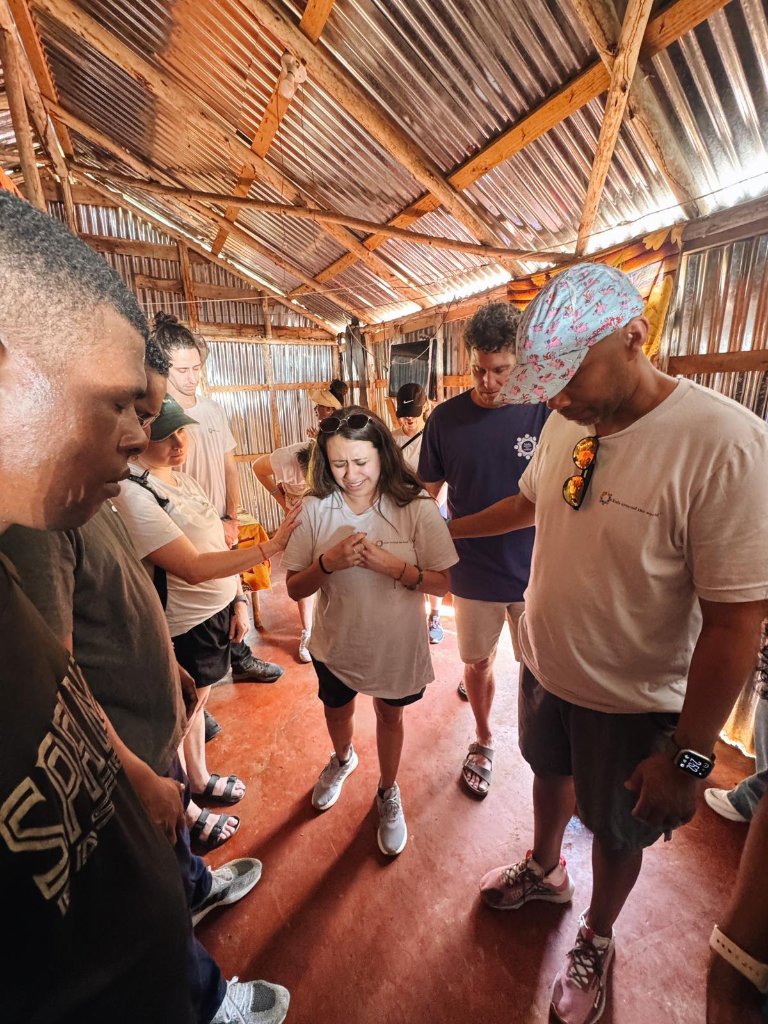 Mission team praying together in a community space