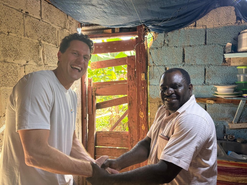 Shaking hands with a local resident inside his home