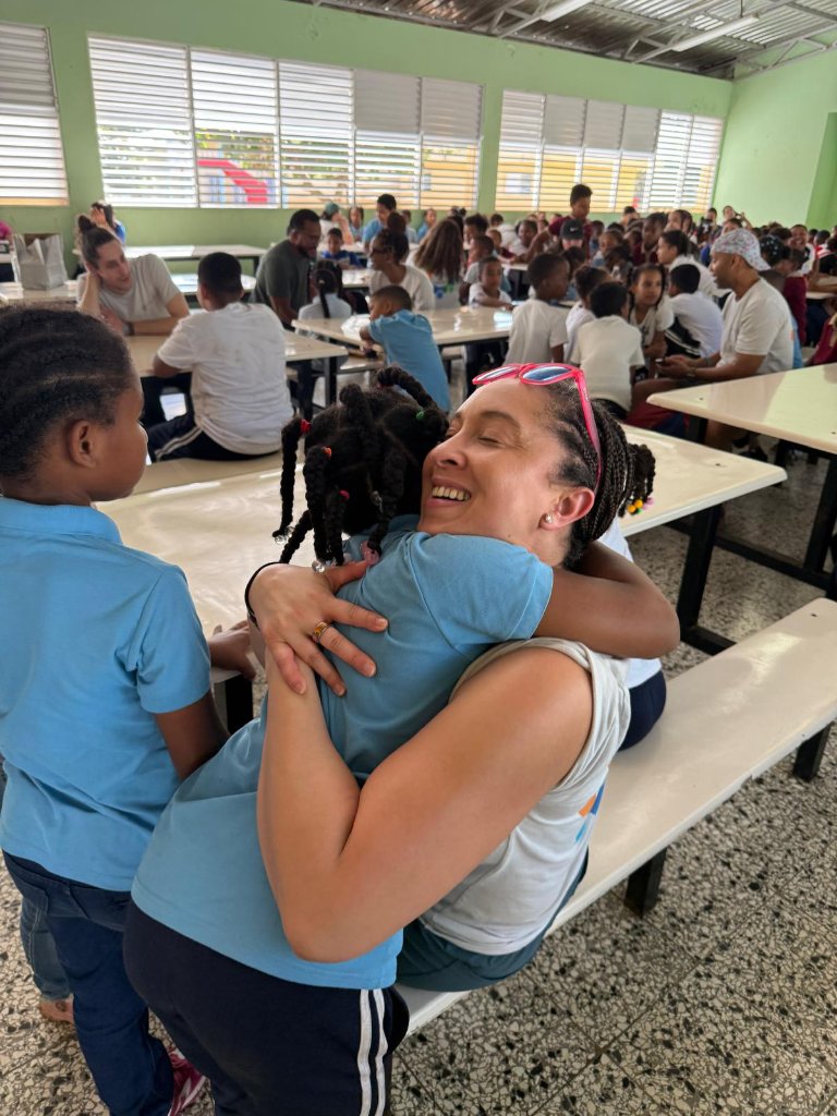 Hugging a child during a school feeding visit