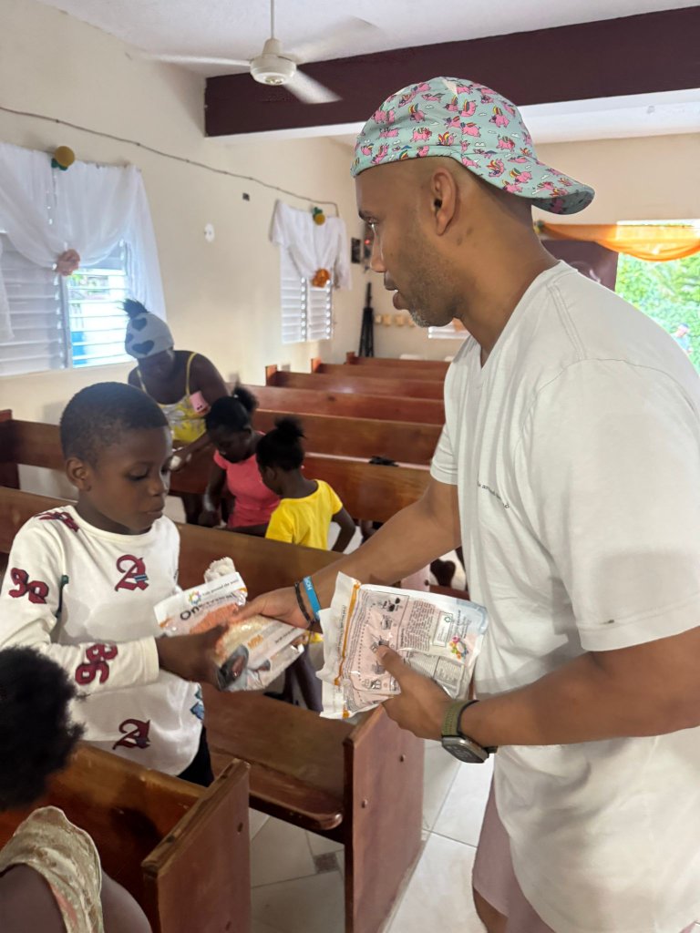 Lucky Rabbit team member handing out meal bags to a child