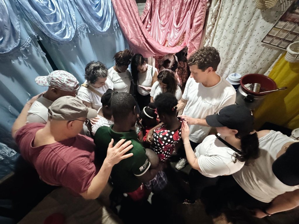 Group praying with families and children