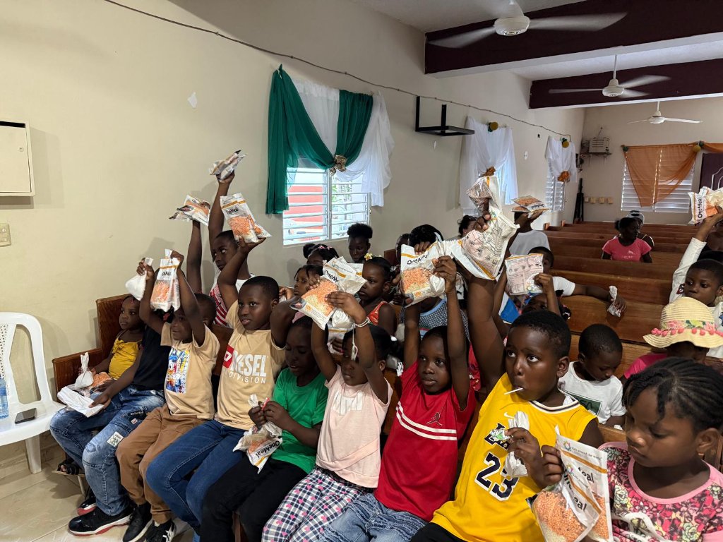 Children raising OneMeal bags in celebration