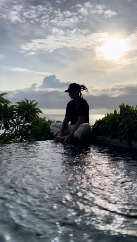 Sitting by infinity pool at sunset