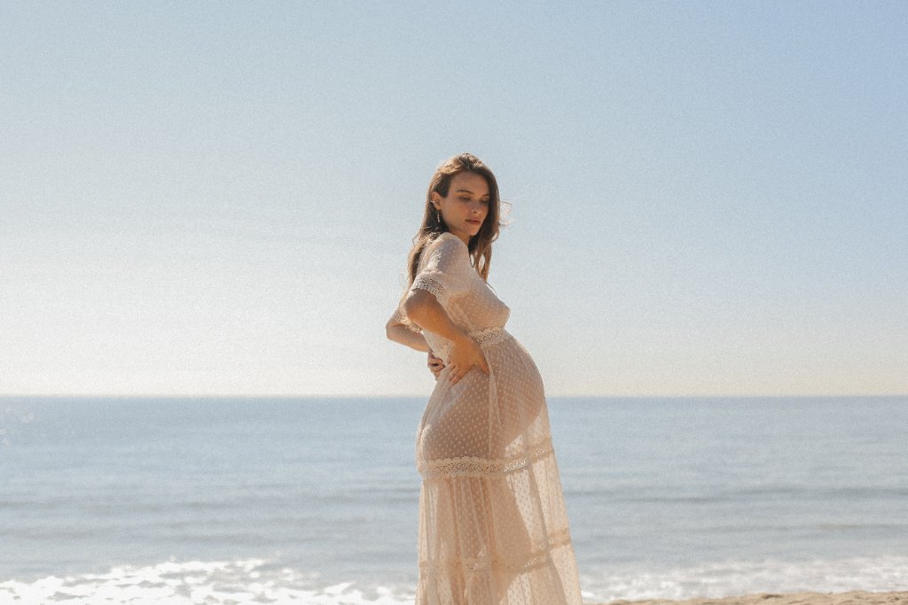 Expecting mother on the beach at sunrise