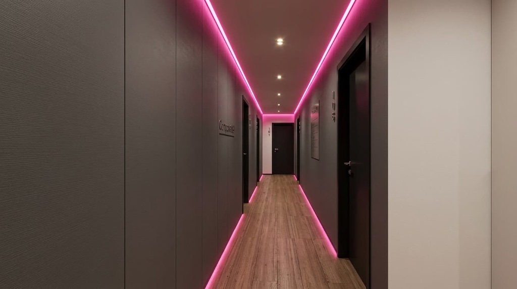 Corredor de circulação do Compass 109 com iluminação LED rosa e portas dos apartamentos