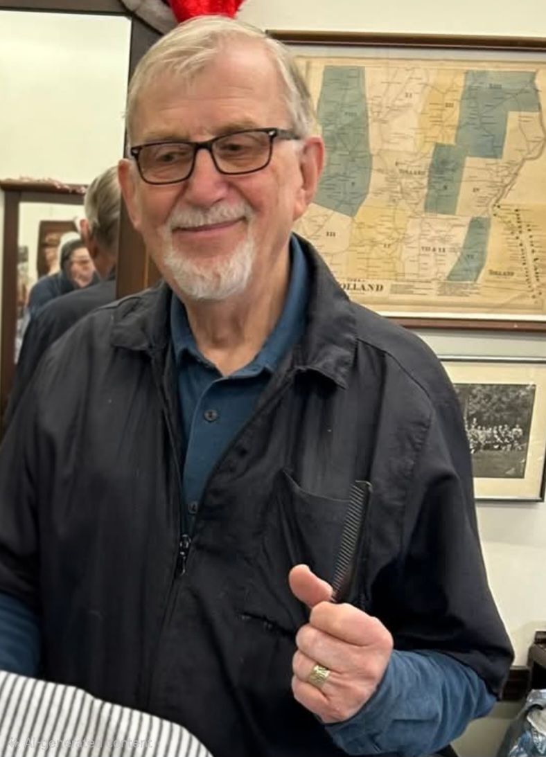Lou, formerly of Tolland Barbers, holding his comb in the shop