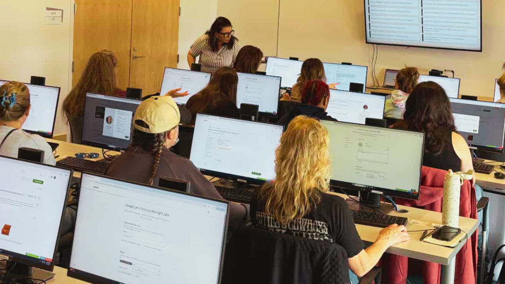 Women attending Freelancing 101 workshop, working on computers with Felicia teaching