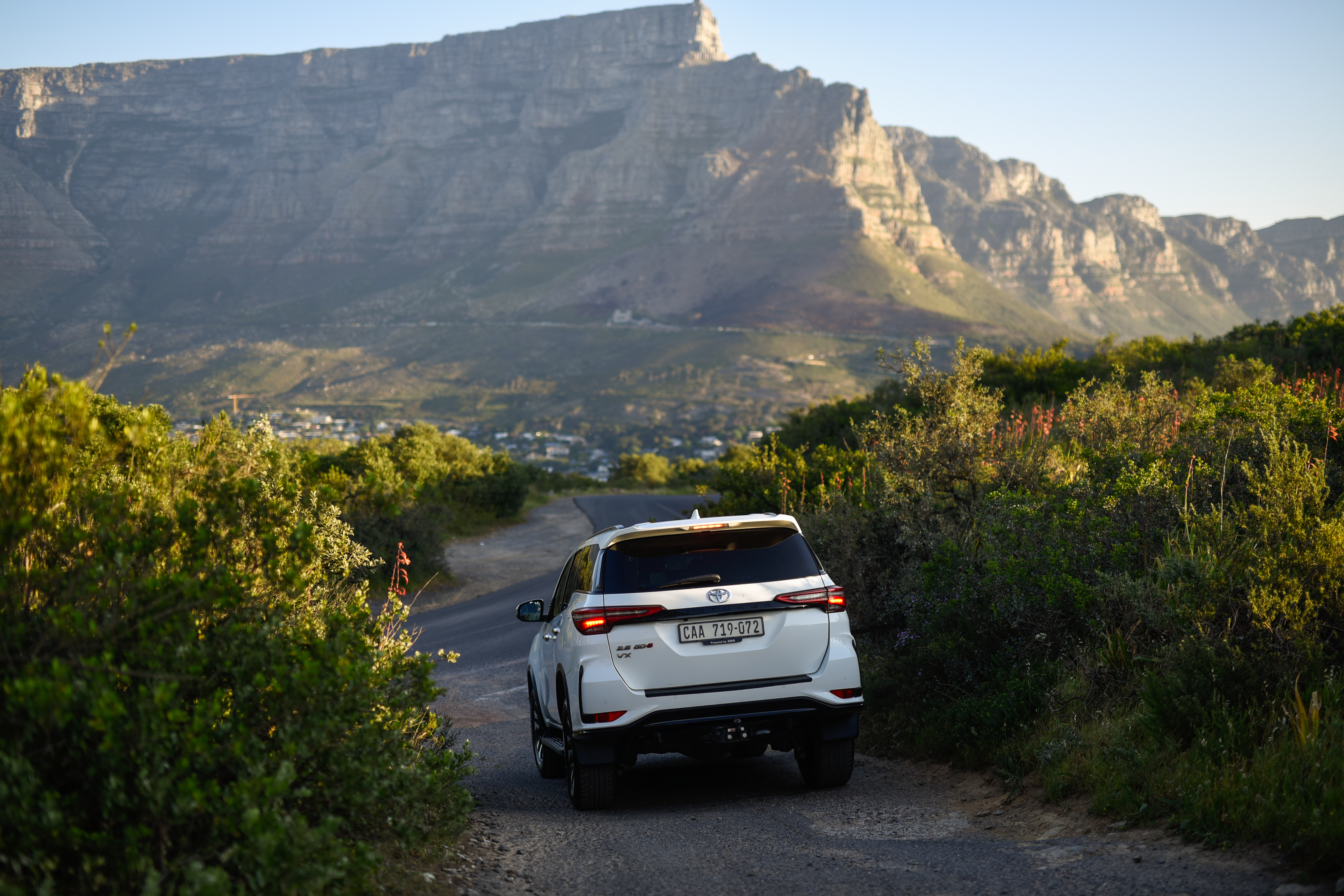 The One Day Africa SUV driving a fynbos road towards Table Mountain