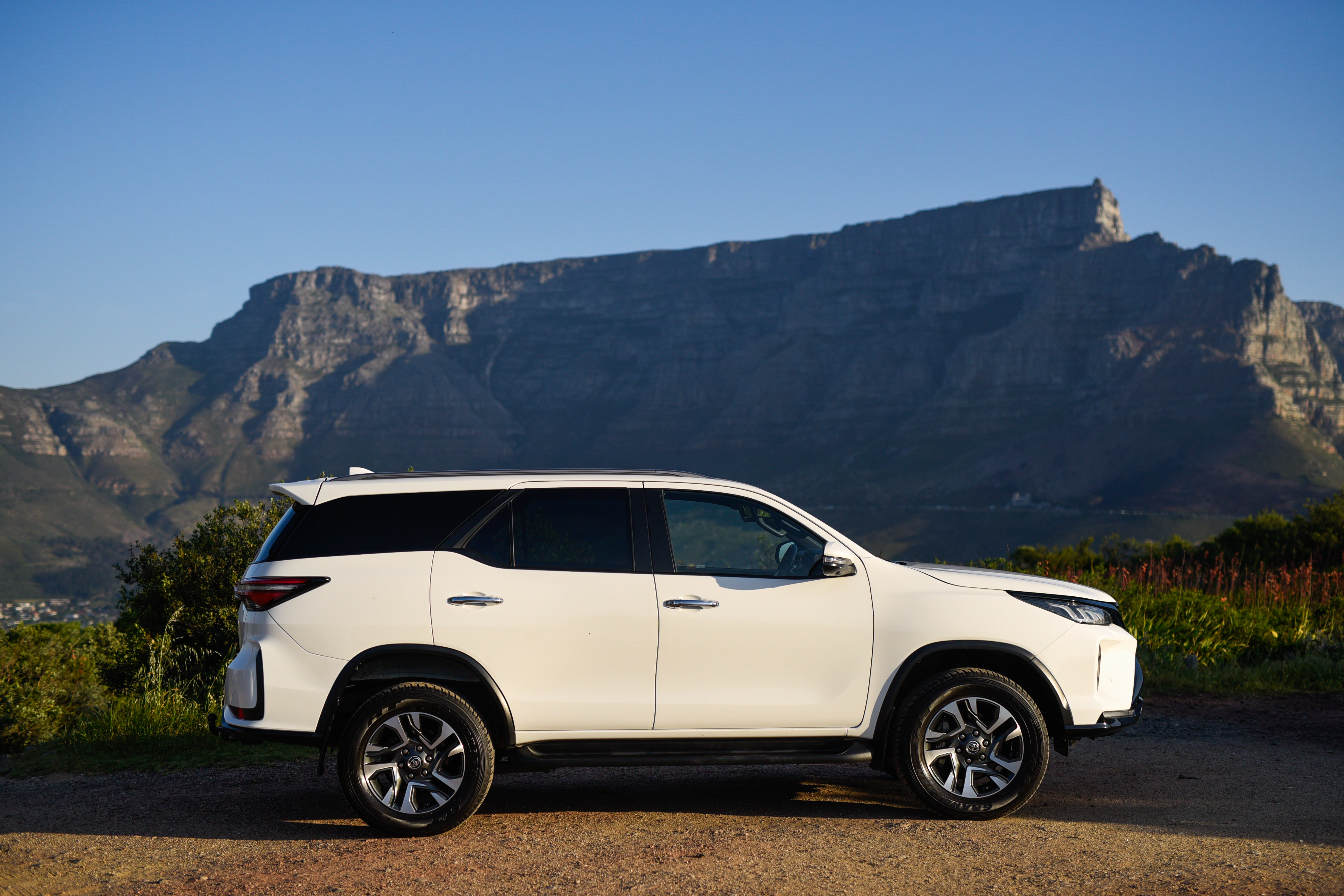 Side view of the One Day Africa 7-seater SUV with Table Mountain behind