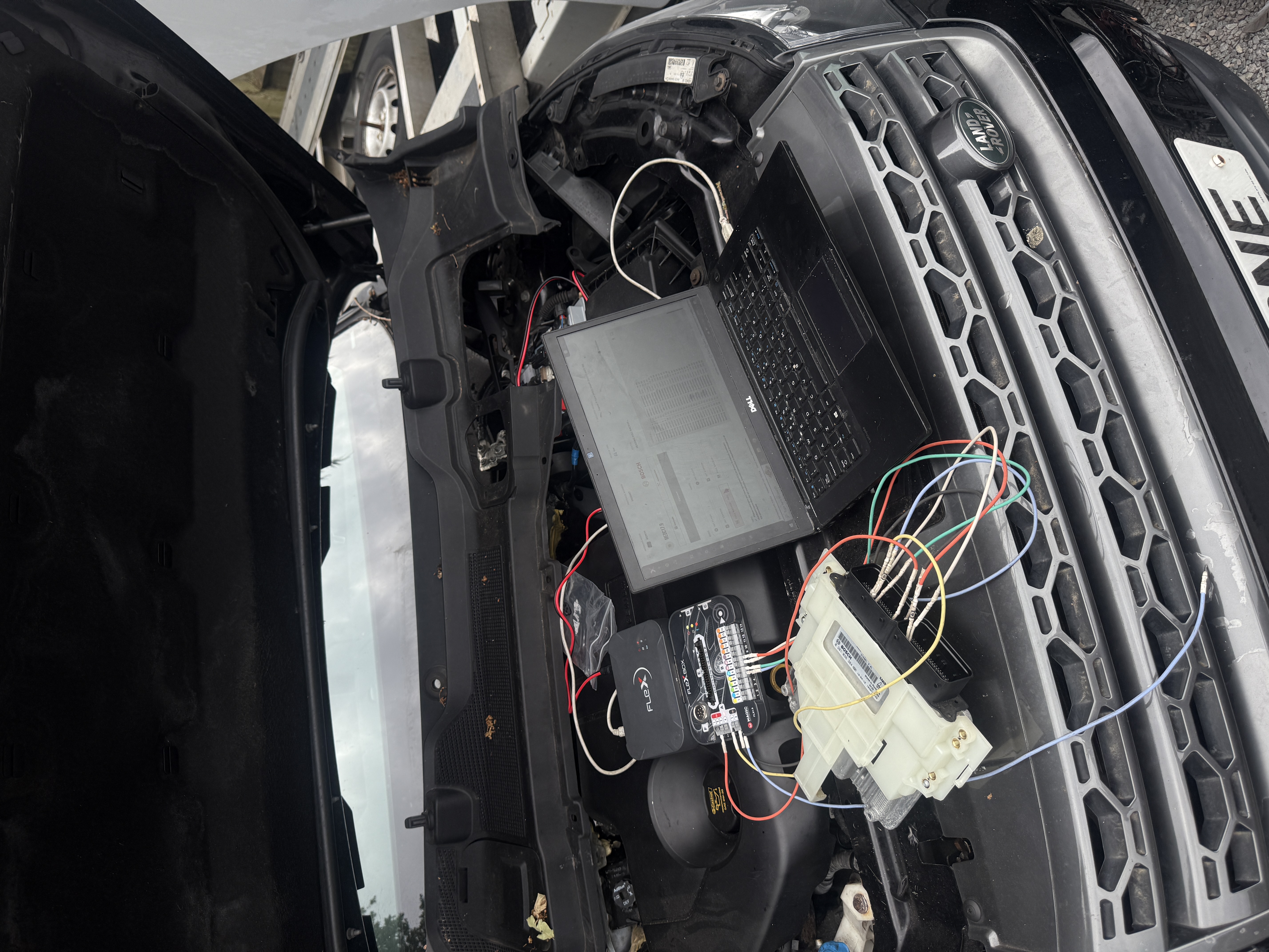 Engine ECU connected to Flex programming equipment and a Dell laptop on a Land Rover at KeyLogik