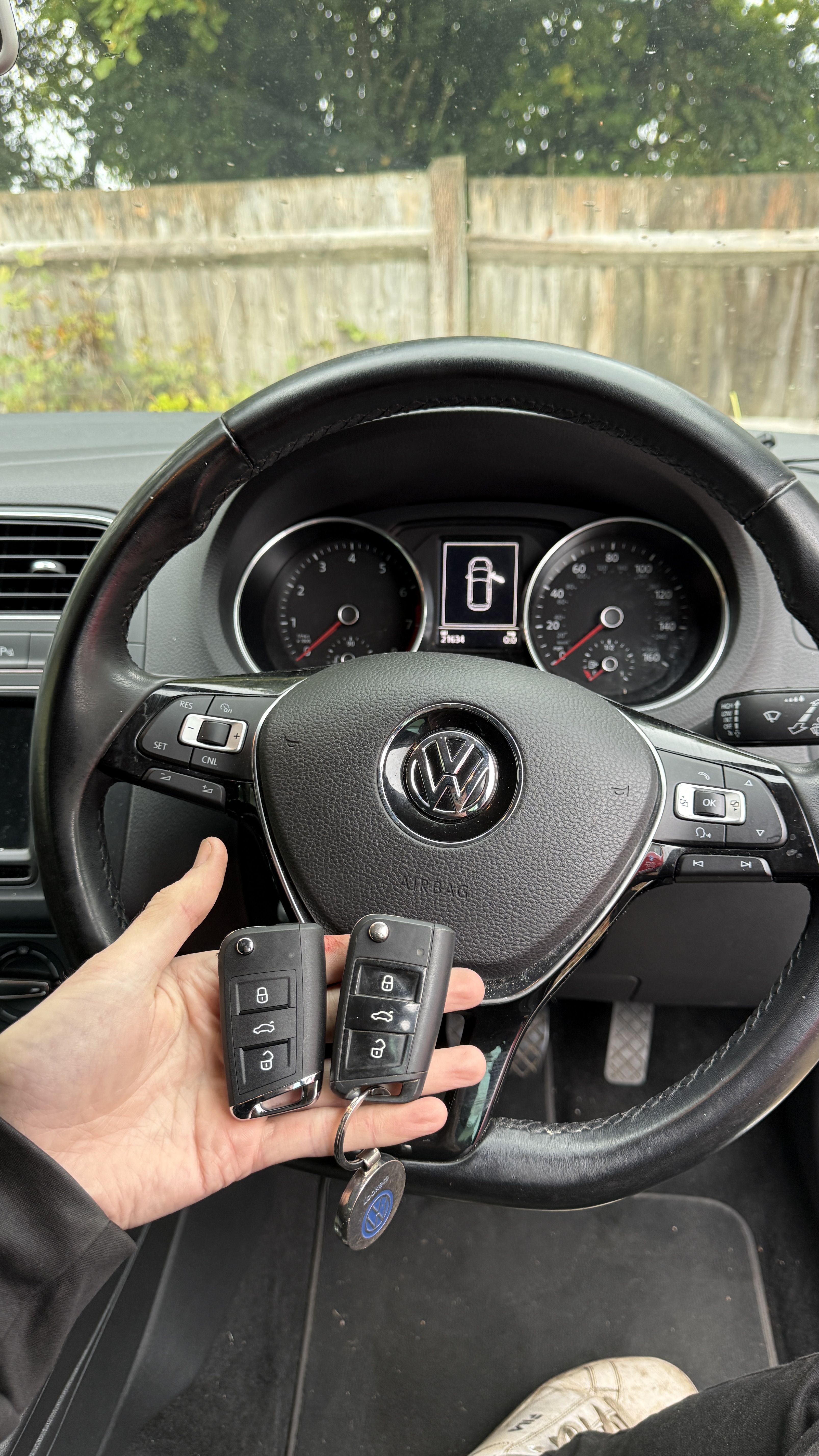 Two Volkswagen keys held at the steering wheel after programming by KeyLogik mobile auto locksmith