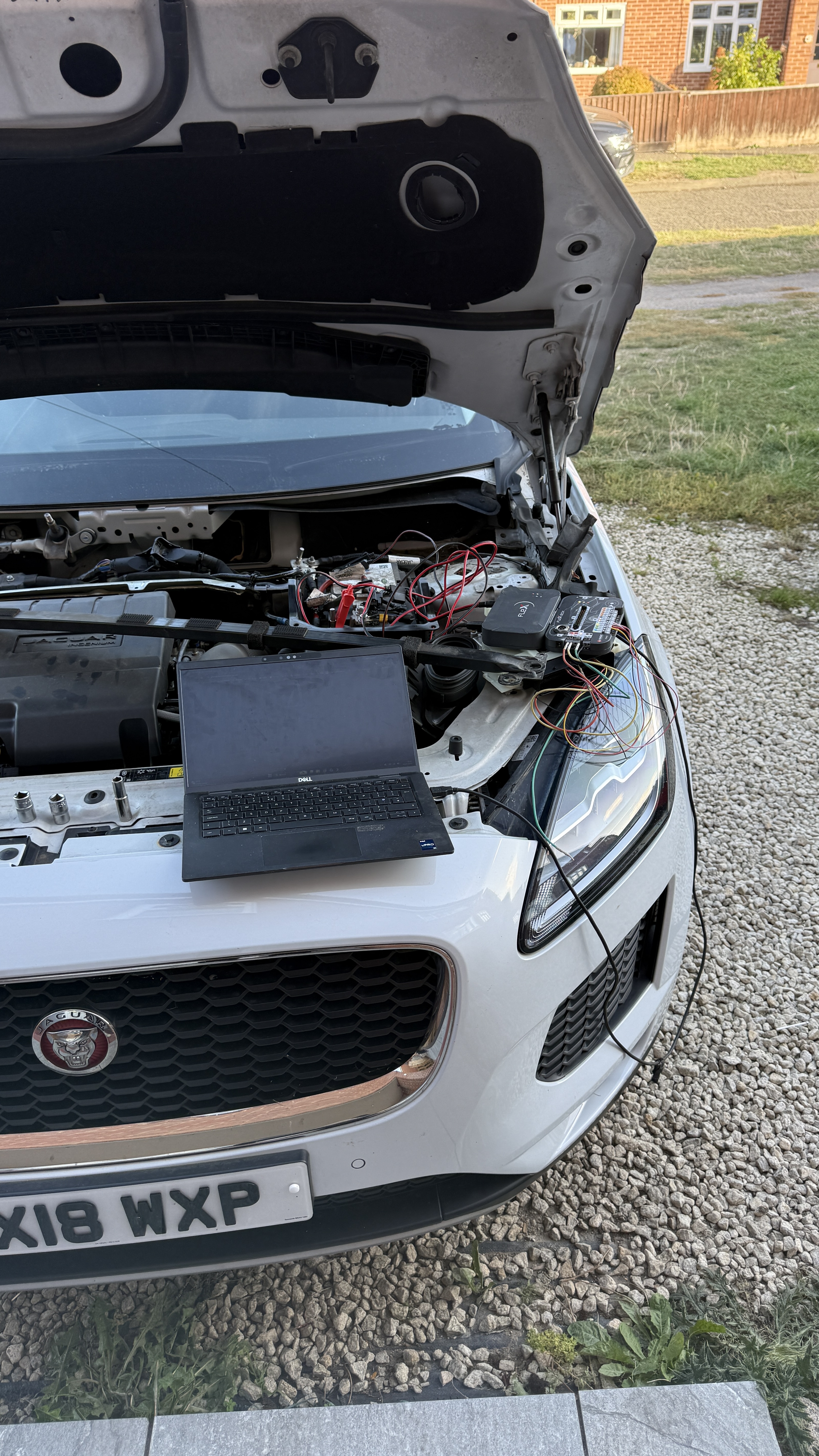 White Jaguar E-Pace with bonnet open and Dell laptop connected to Flex diagnostic equipment during ECU remapping by KeyLogik in Didcot, Oxfordshire