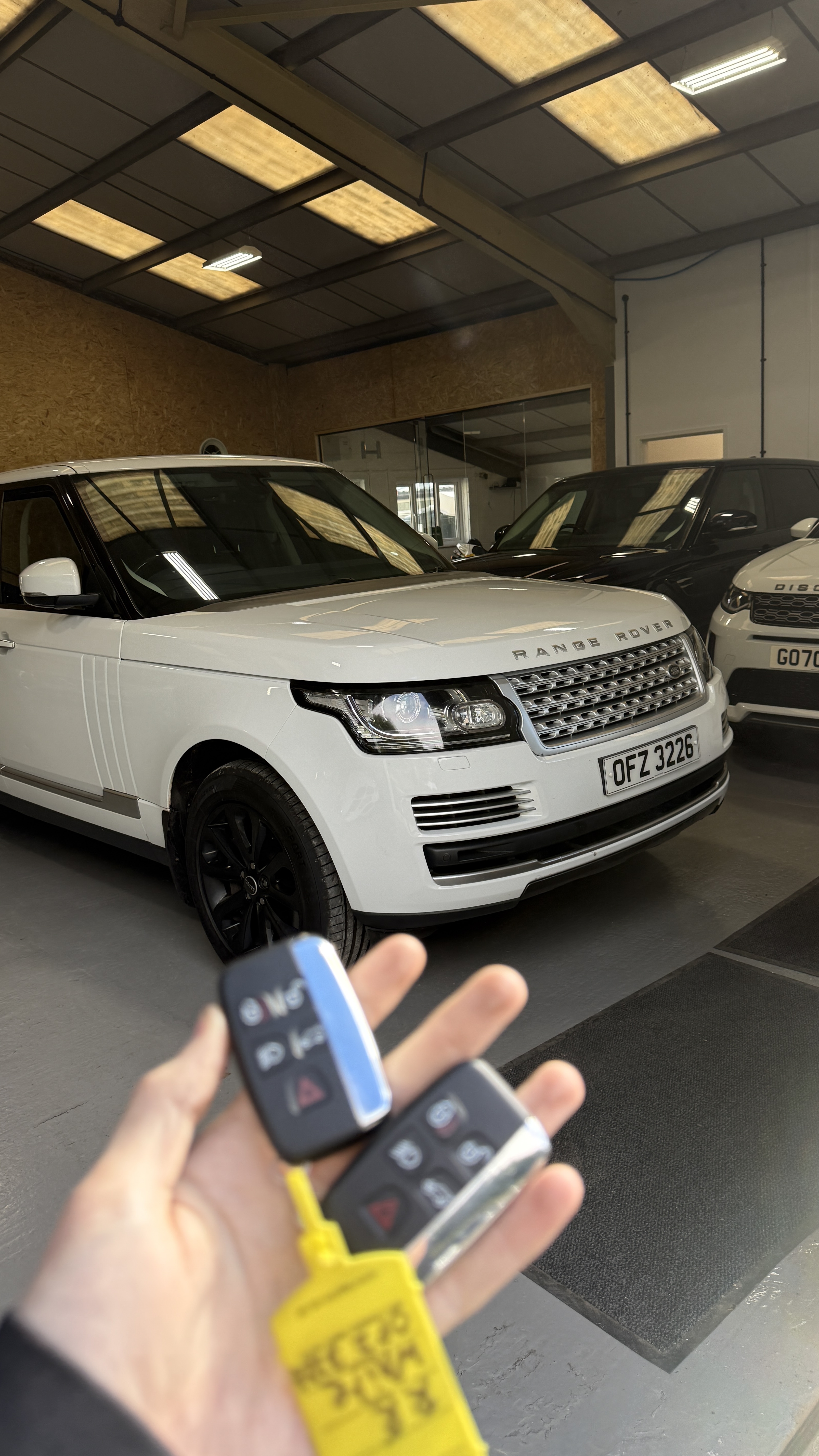 Two key fobs supplied and programmed for a white Range Rover by KeyLogik mobile auto locksmith