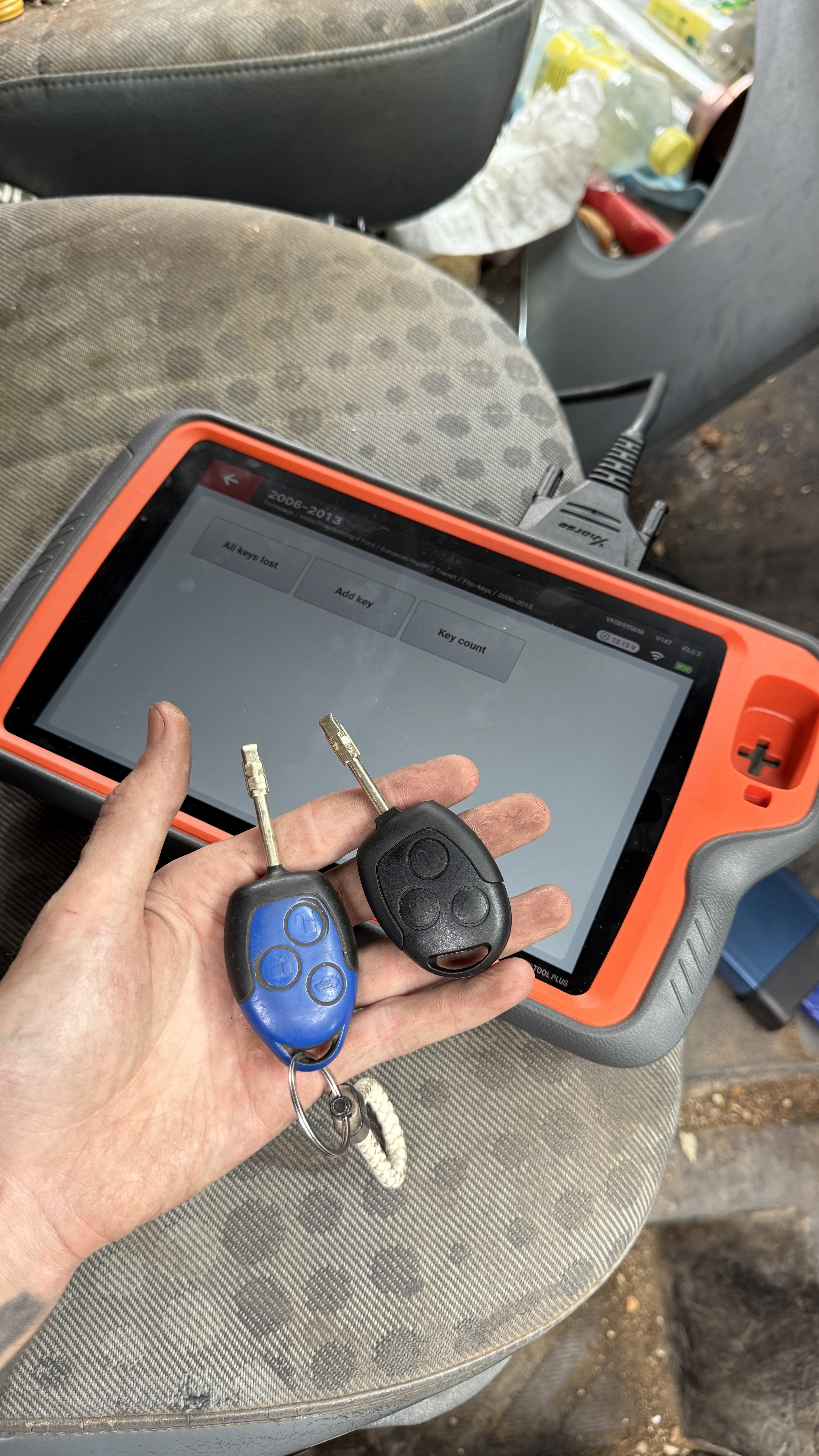 Ford Tibbe keys alongside an automotive diagnostic programming tablet used to program the transponder to the vehicle