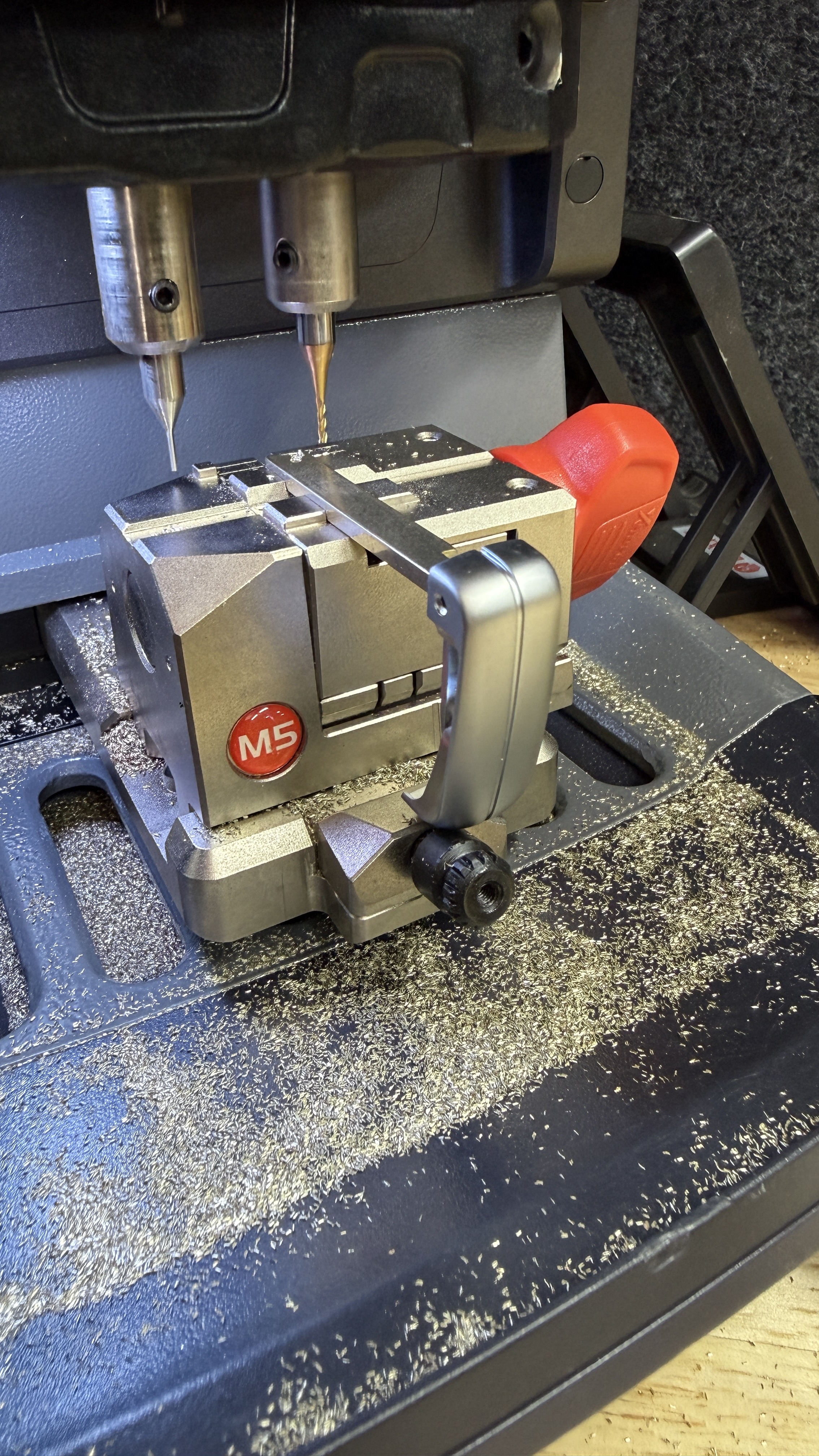 Close-up of the M5 cutting clamp and gold milling cutter used to produce replacement car key blades by KeyLogik