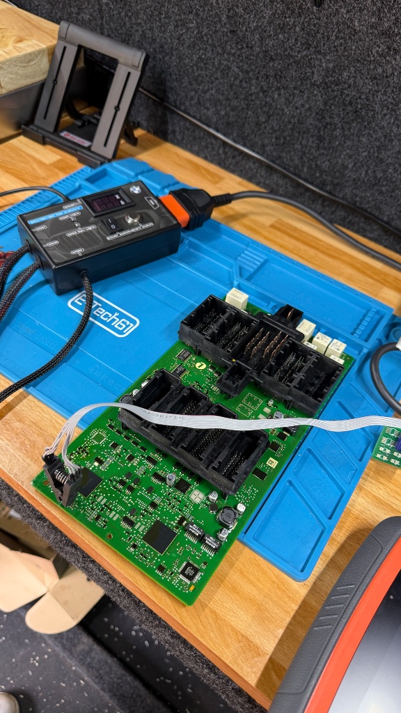 BMW M140i FEM circuit board on anti-static mat with SOIC8 adapter on workbench in Abingdon