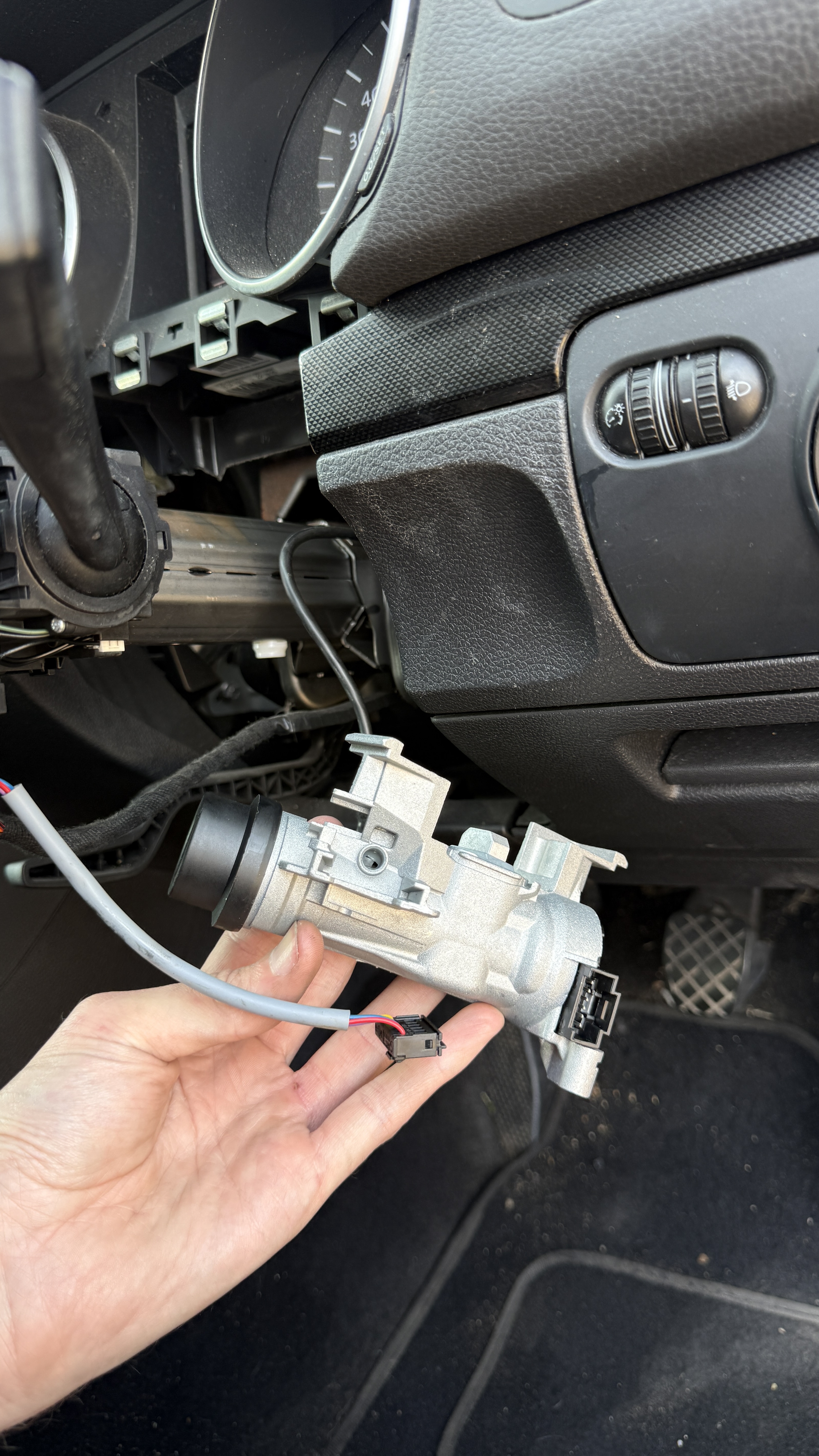 Replacement Volkswagen ignition lock housing being held inside the vehicle during a KeyLogik repair