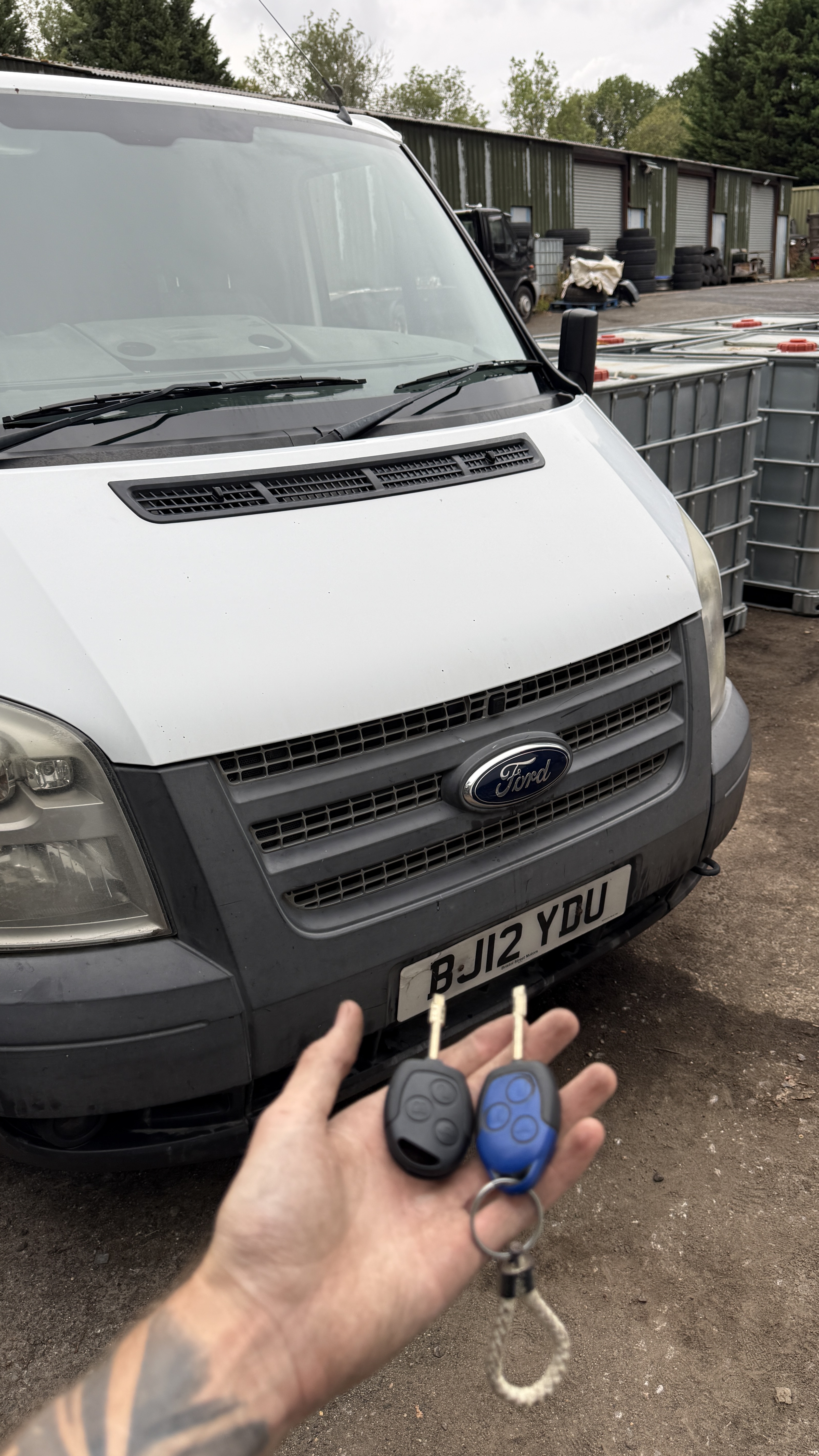 A blue Ford Transit Tibbe key held alongside a standard Ford key — the distinctive blue fob and Tibbe blade