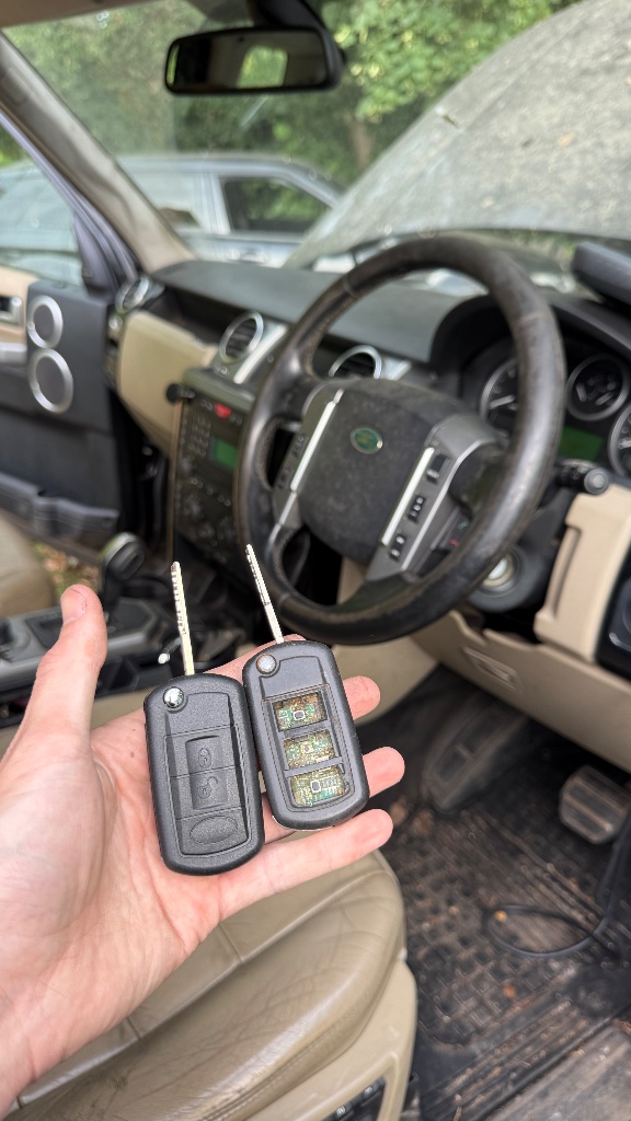 Damaged original Land Rover Discovery 3 key with missing buttons alongside new OEM-style replacement key supplied by KeyLogik in Henley-on-Thames, Oxfordshire