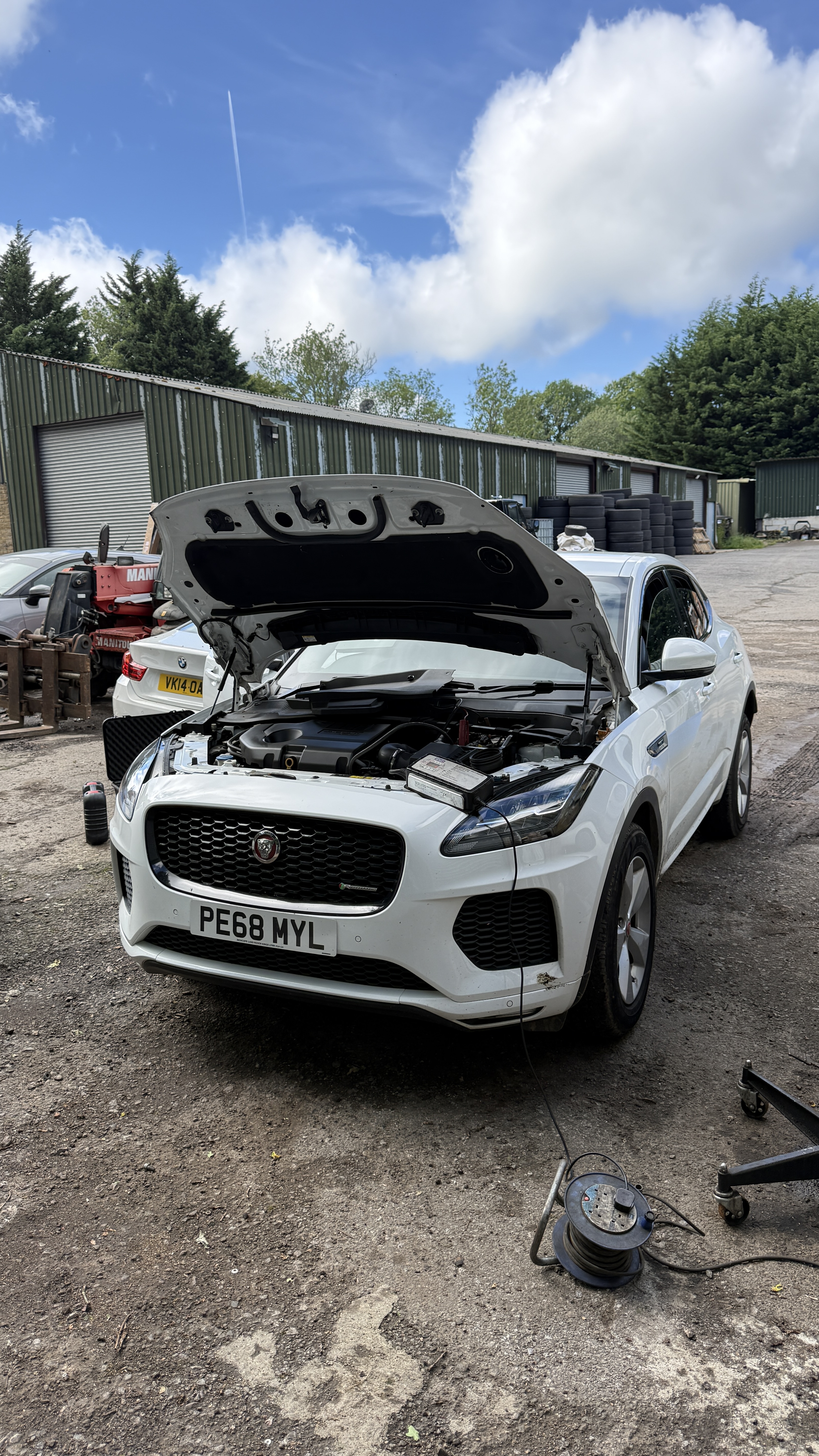 White Jaguar F-Pace with bonnet open and Sealey battery support unit connected, AdBlue delete carried out by KeyLogik in High Wycombe