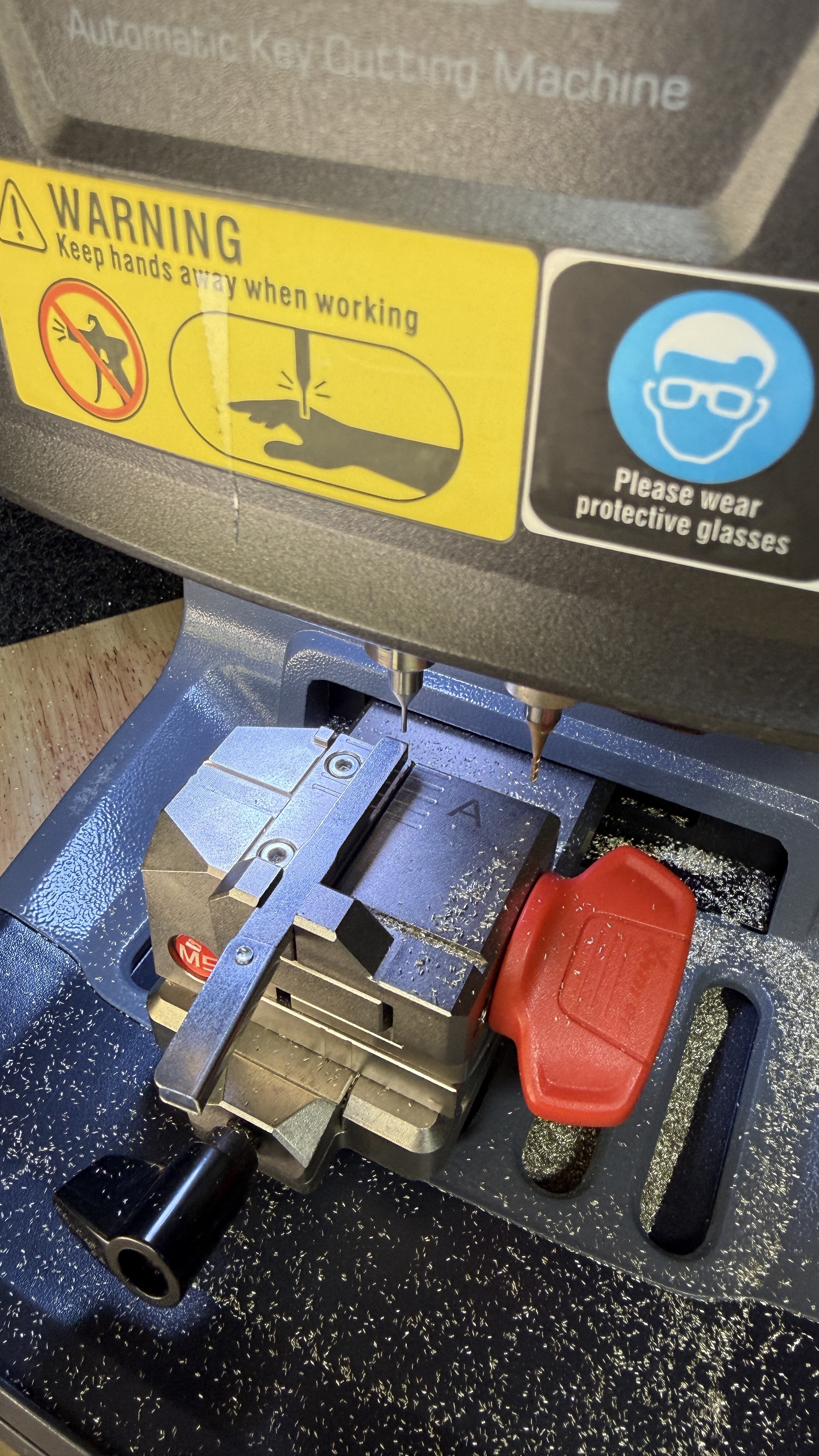 Xhorse automatic key-cutting machine cutting a car key blade, used by KeyLogik mobile auto locksmith