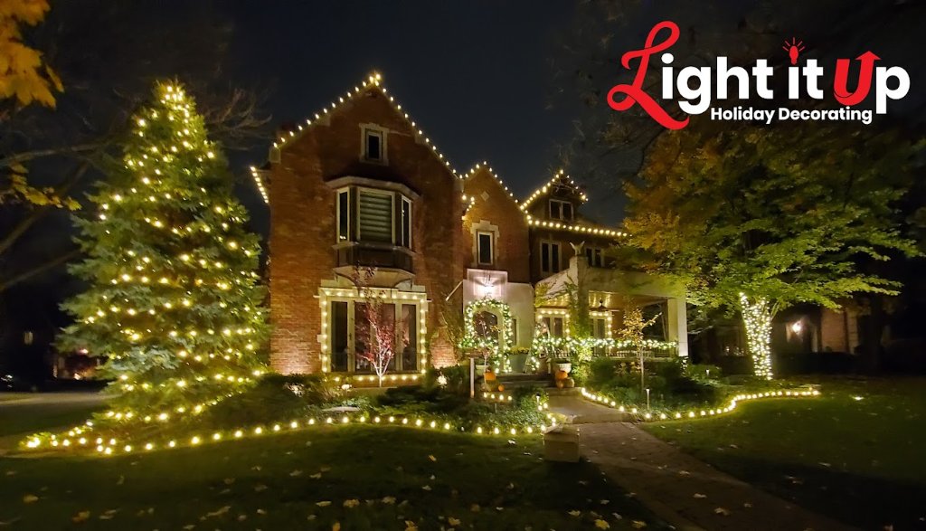 Warm white roofline, wrapped tree and pathway lights on brick estate